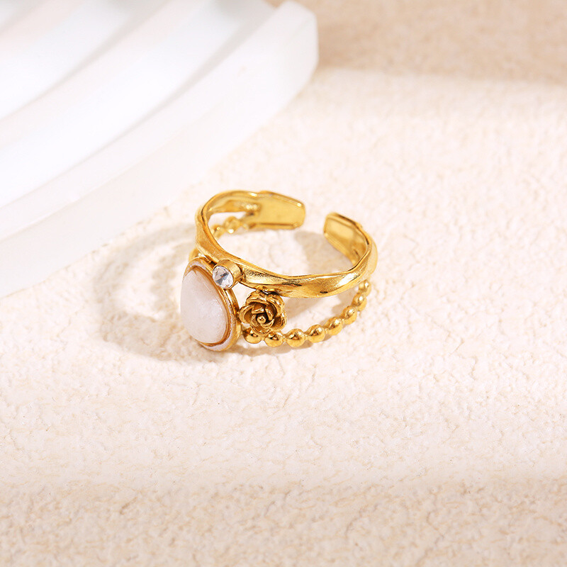 Grossista Eclat Paris - Anello dorato con fiore, strass e pietra bianca a goccia