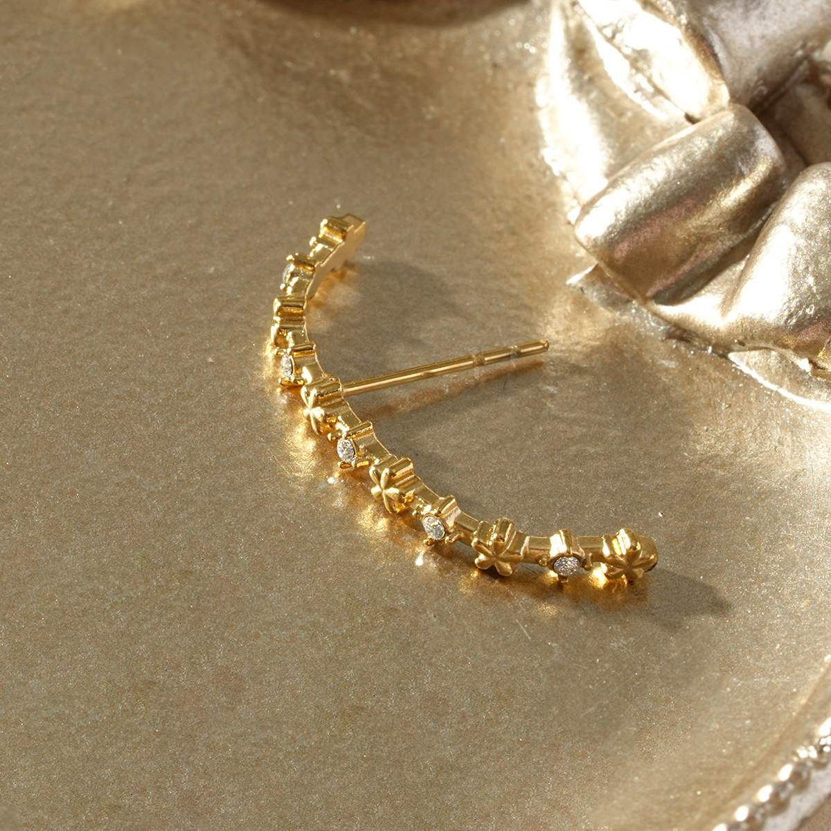 Wholesaler Eclat Paris - Unique gold arc earring adorned with flowers and minimalist rhinestones