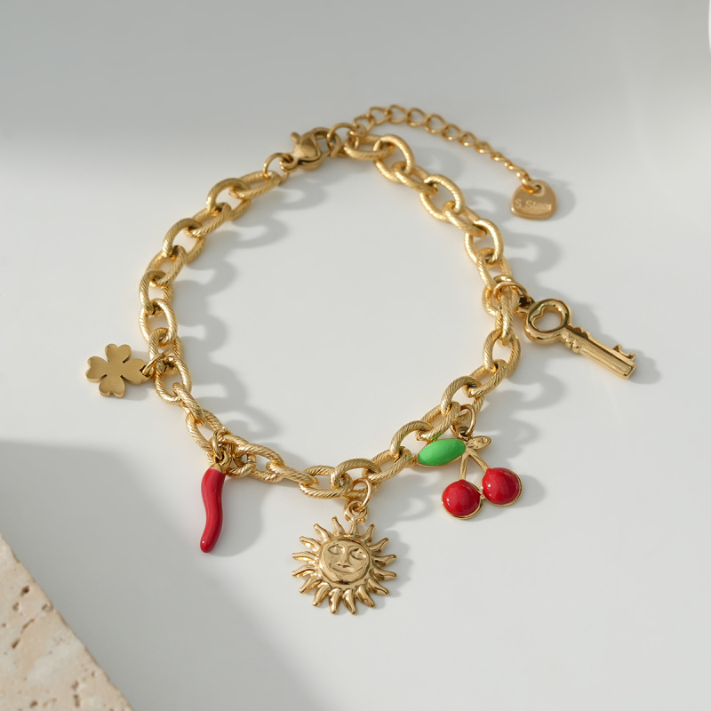 Mayorista Eclat Paris - Pulsera dorada con múltiples colgantes de sol y cerezas.