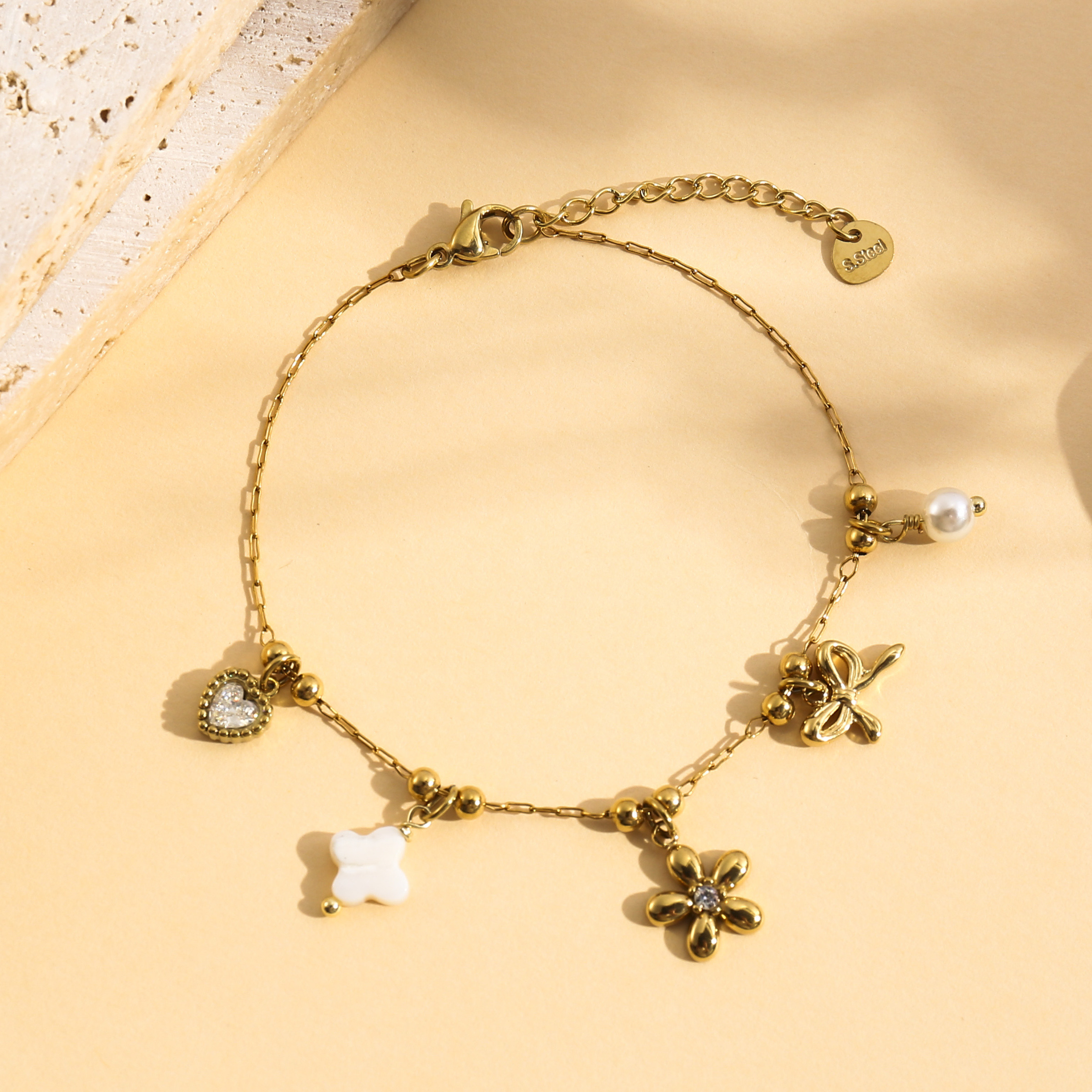 Wholesaler Eclat Paris - Gold charm bracelet with flower, bow, and rhinestone heart