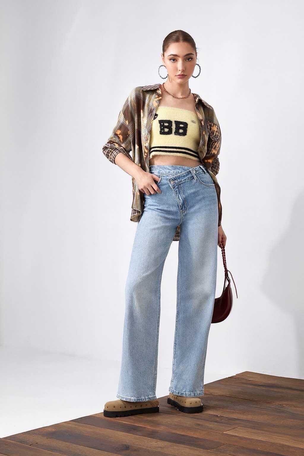 Adoptez un style audacieux avec ce jean asymétrique à coupe wide leg. Conçu dans une matière stretch de qualité, il offre un confort optimal tout en sublimant la silhouette grâce à sa taille haute. Sa fermeture décalée apporte une touche originale et tendance. 
Longueur totale : 100 cm
Information importante :
En raison des caractéristiques naturelles de la teinture utilisée pour le denim, une exposition prolongée à la lumière (notamment aux rayons UV directs) peut entraîner une légère décoloration progressive du tissu. Il est recommandé de stocker le produit à l’abri de la lumière et de limiter son exposition prolongée au soleil pour préserver l’intensité de sa couleur.