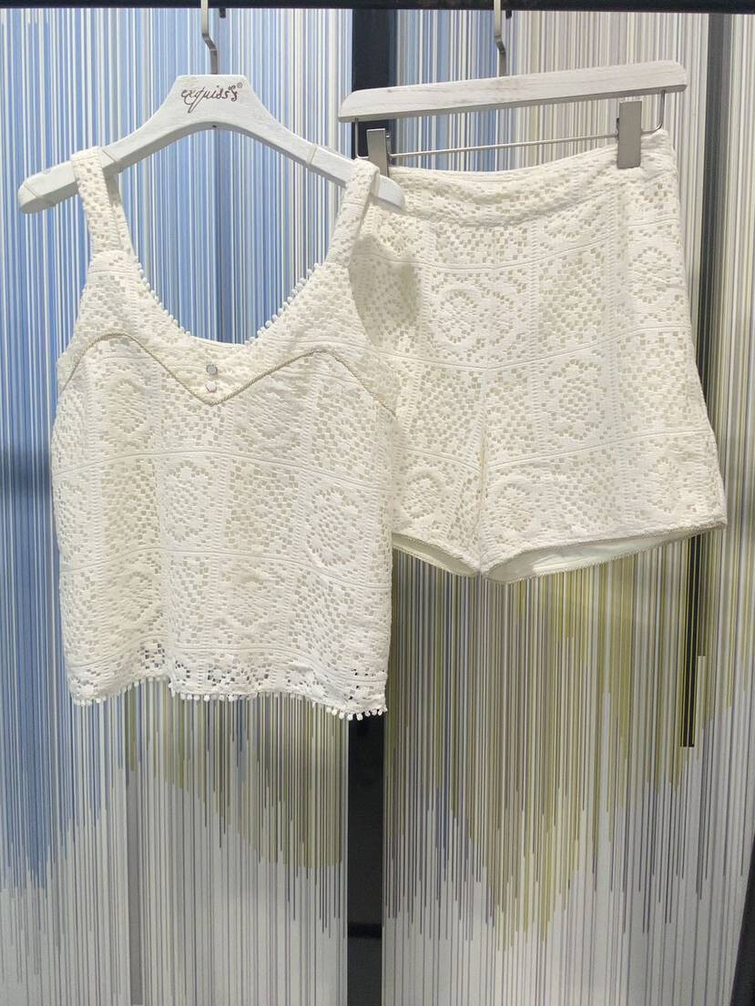 Top with thin straps and a V-neckline, adorned with buttons, and coordinated shorts with crochet detail, perfect for a casual summer look. Exquiss's Paris