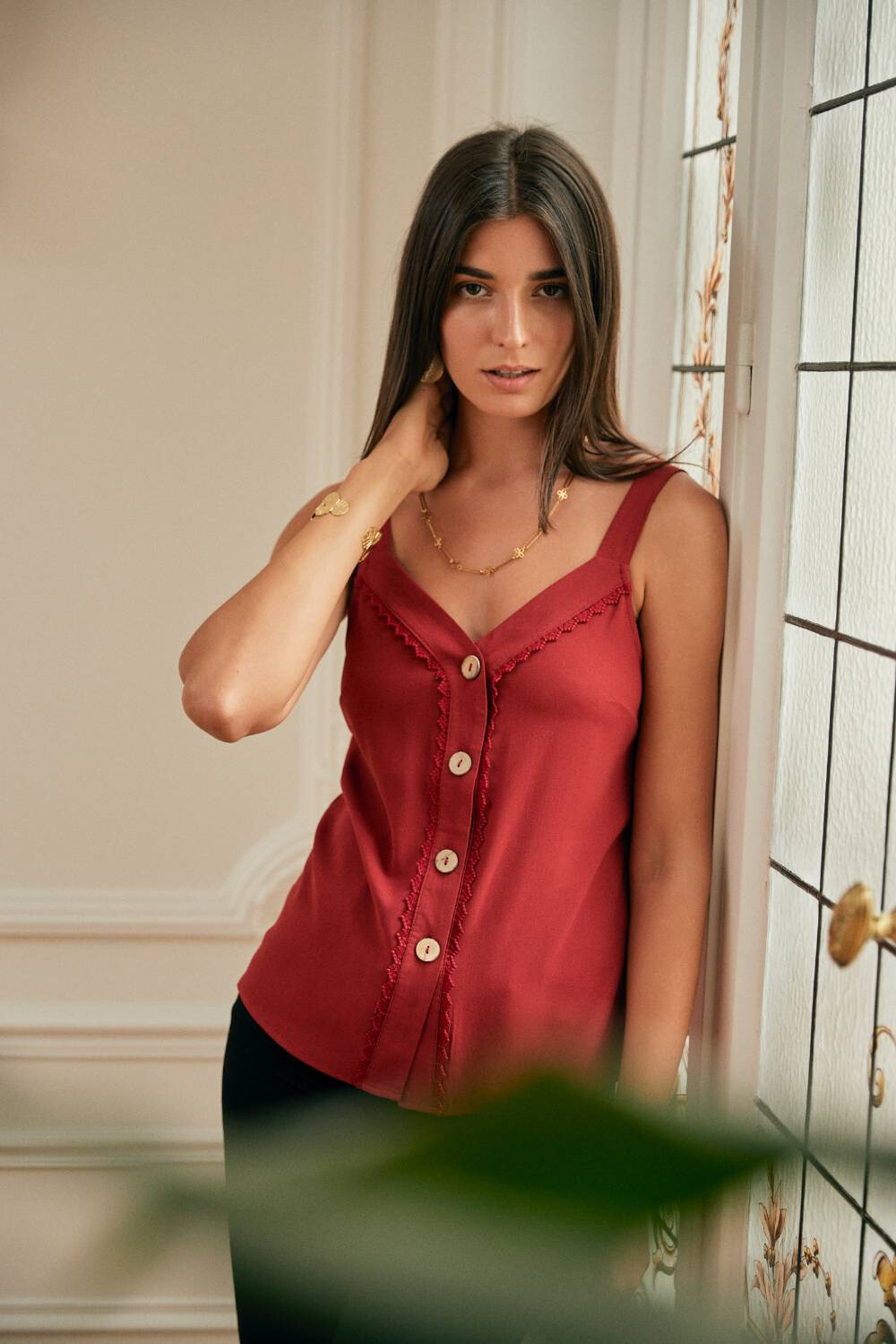 This feminine top features wide straps and a V-neckline. It closes with buttons at the front and showcases lace details. Its fitted cut enhances the silhouette while offering optimal comfort. Exquiss's Paris