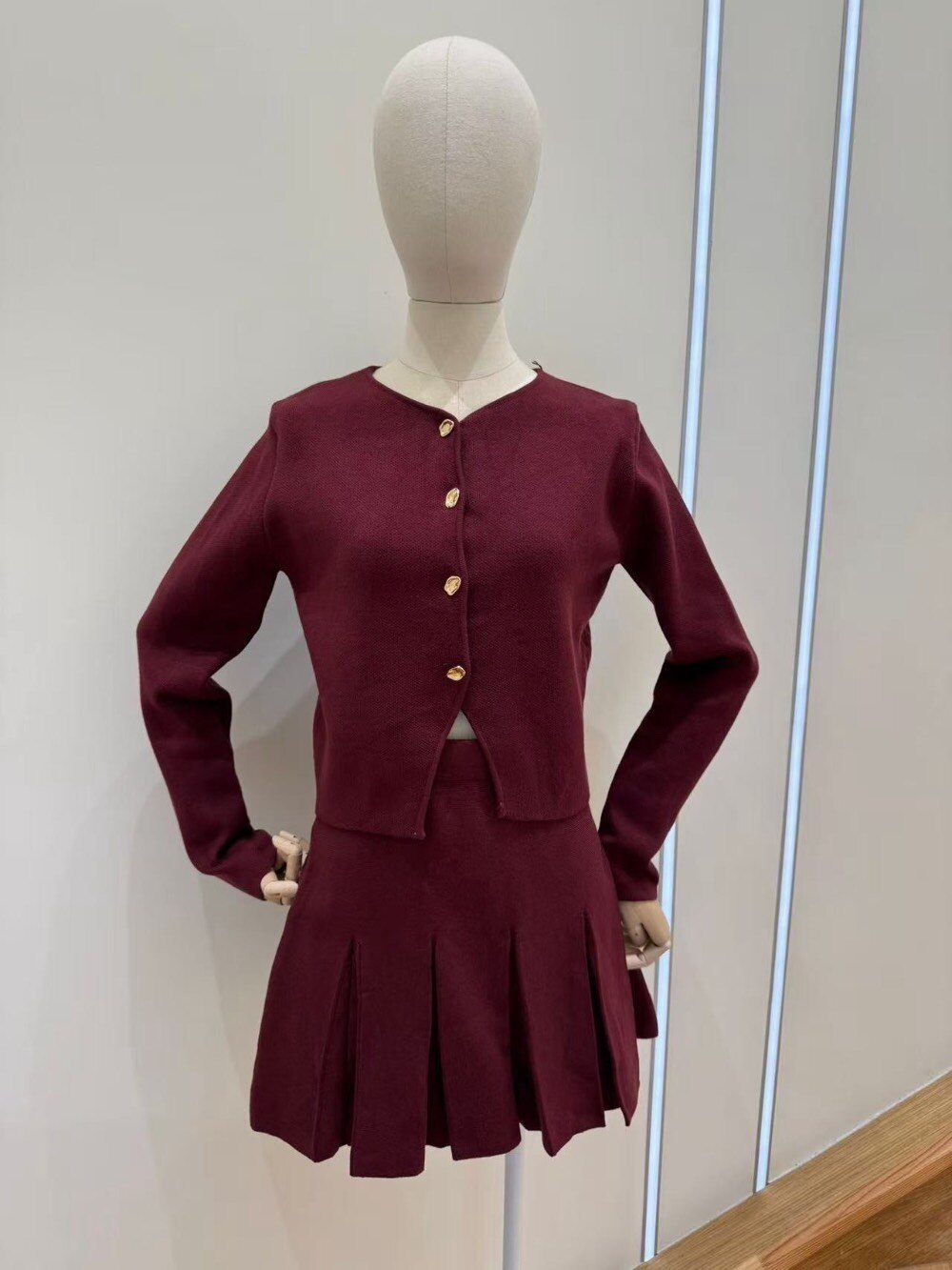 Elegant set in soft mesh including a round -neck cardigan closed by pretty golden buttons and a short skirt with flat folds. A feminine and comfortable look, perfect for mid-season or for a relaxed chic style. Available in several trendy colors.