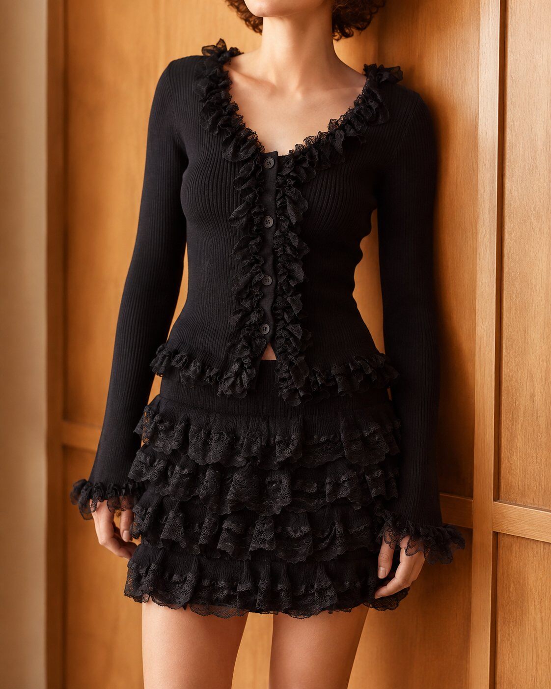 Grossiste Giorgia - Ensemble noir en maille côtelée : gilet à volants de dentelle et mini-jupe échelonnée