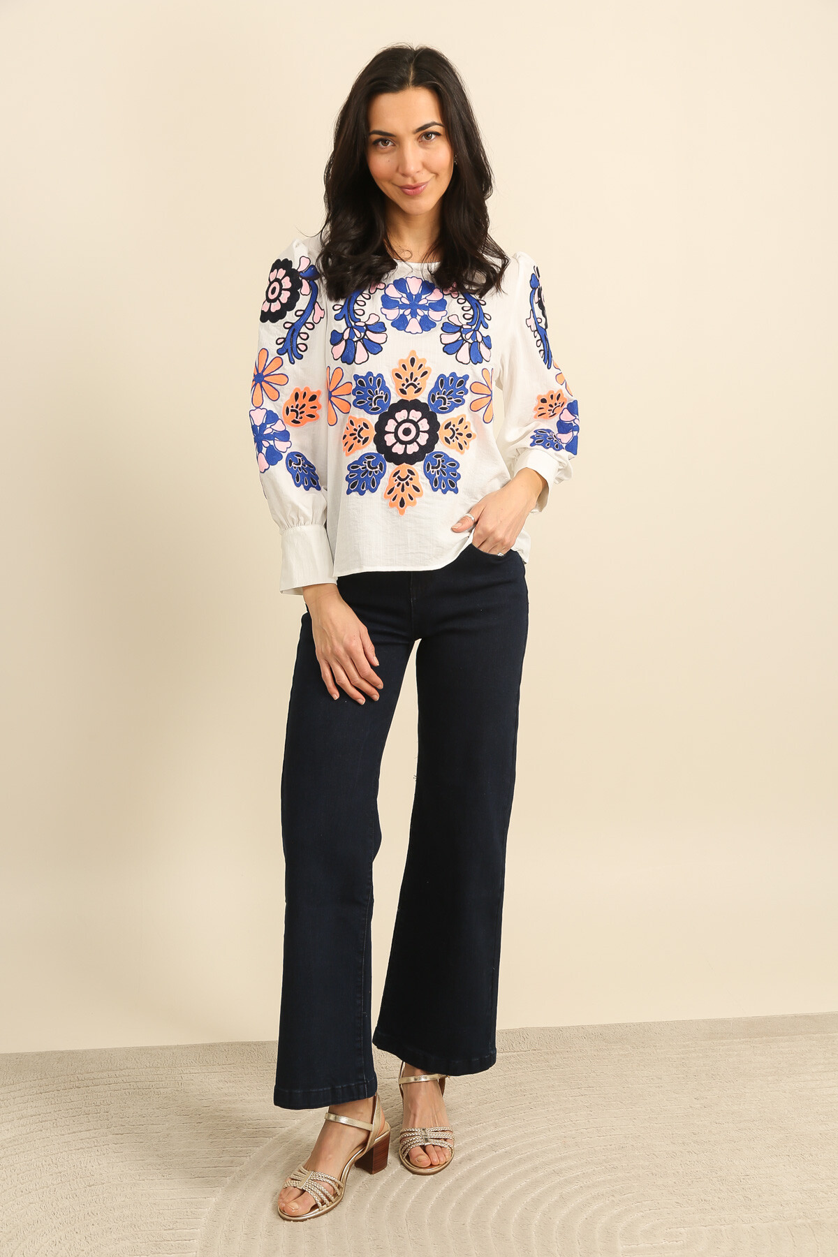 Grossiste Inspiration Studio - Blouse en coton écru, broderies florales multicolores et manches longues structurées.