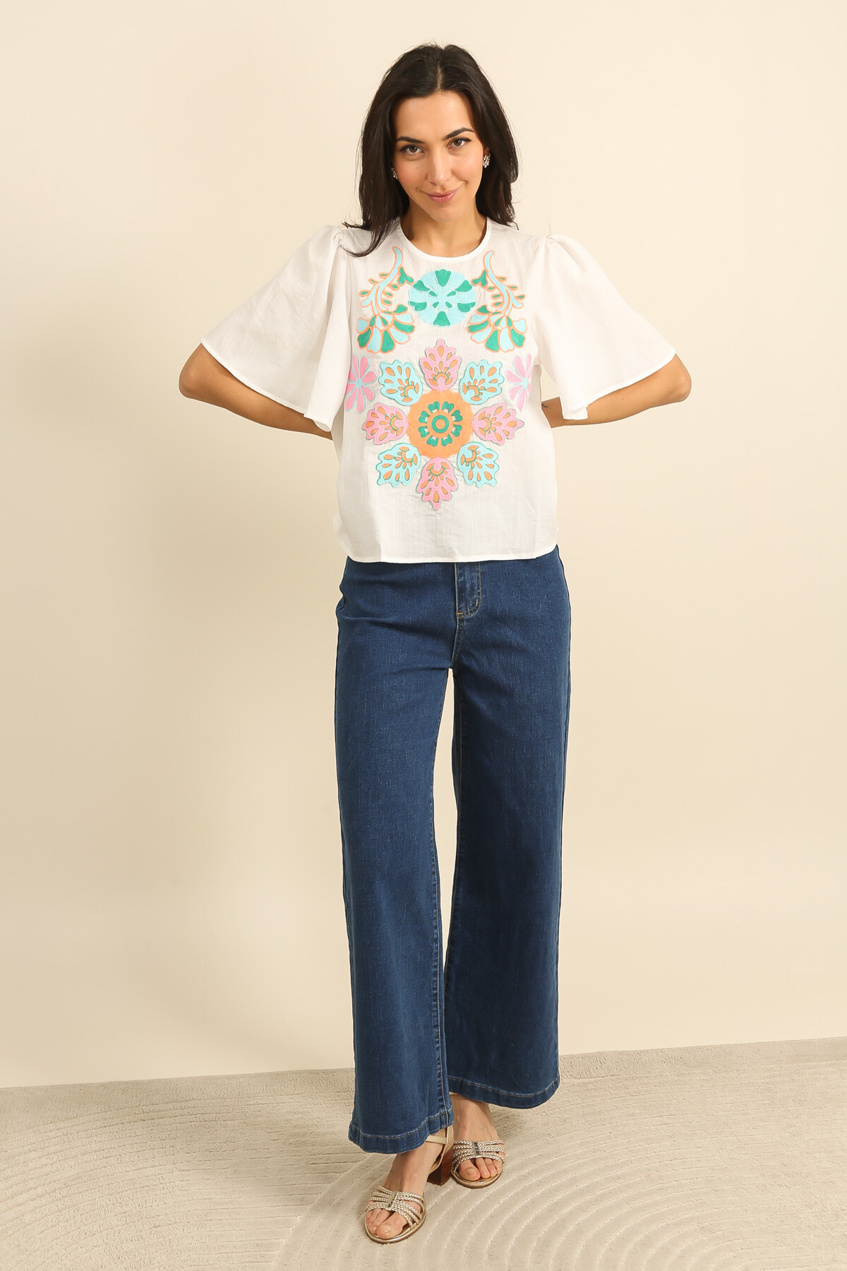 Grossiste Inspiration Studio - Blouse en coton écru, broderies florales multicolores et manches courtes fluides.