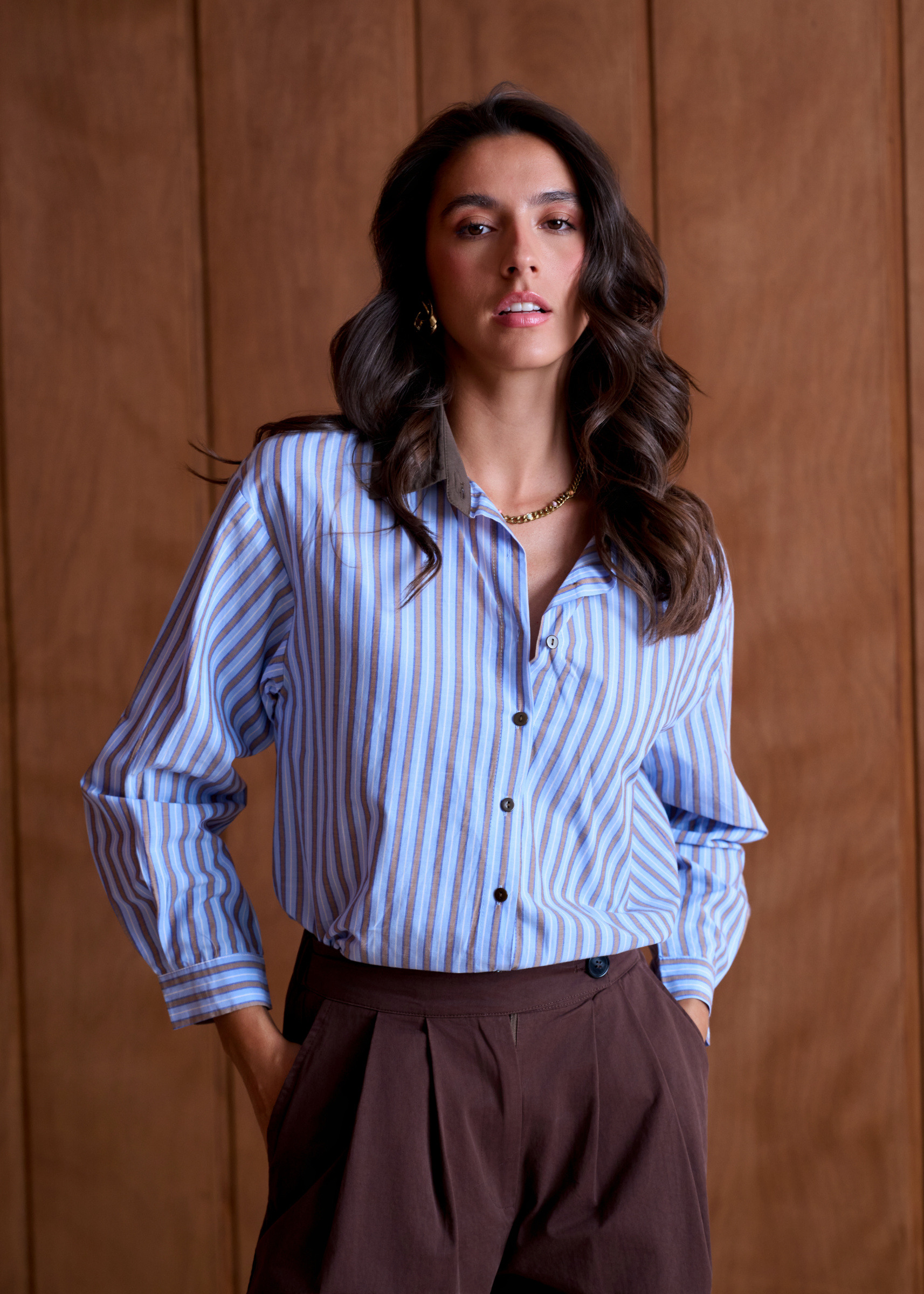 Mayorista Inspiration Studio - Camisa a rayas azul cielo y marrón, con cuello en contraste marrón oscuro, botones negros y dobladillo redondeado más largo en la parte trasera.