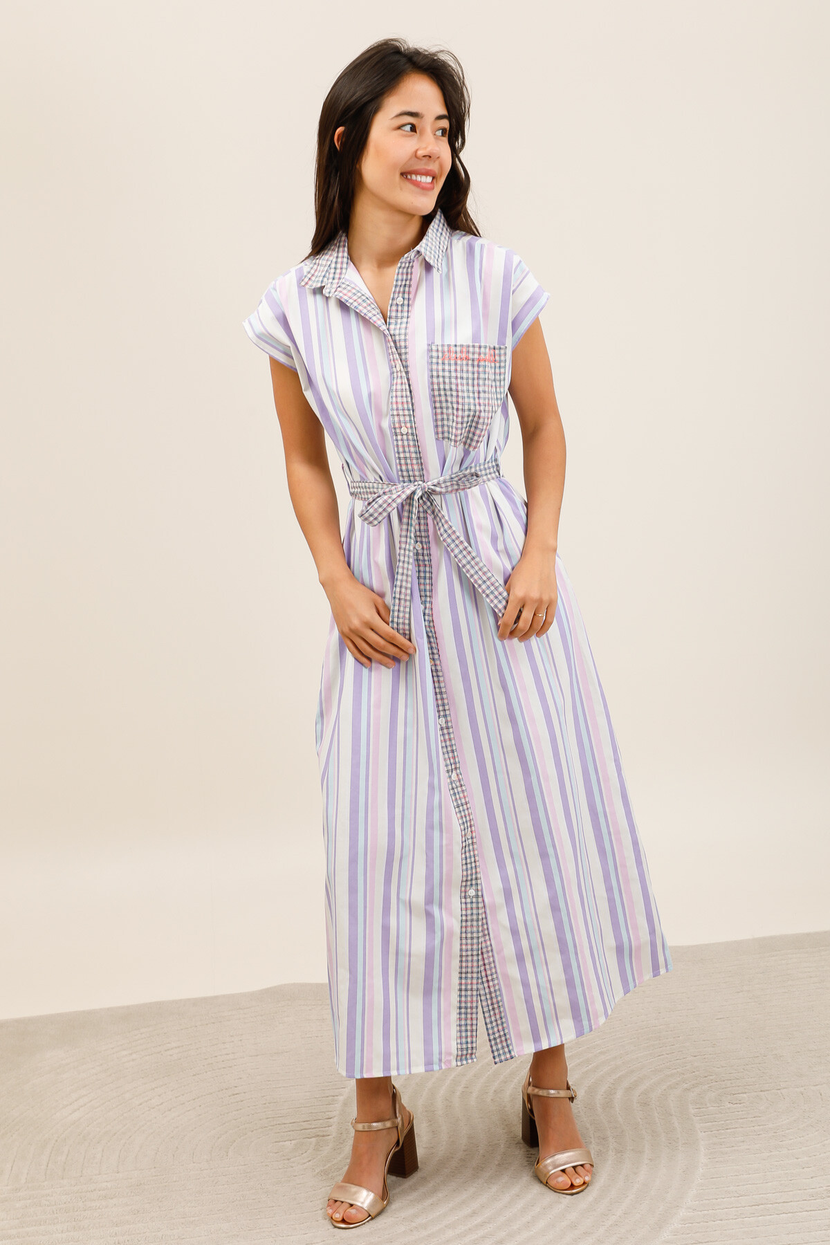 Grossiste Inspiration Studio - Robe chemise longue à rayures pastel, avec détails à carreaux, ceinture à nouer et broderie “Club Soleil” sur la poche poitrine.