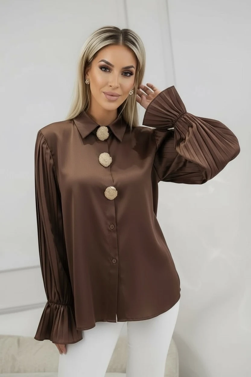 Élégante et raffinée, cette chemise satinée se distingue par ses manches plissées et ses boutons dorés bijoux. Sa coupe droite et son tissu fluide offrent un tombé chic idéal pour un look habillé ou de soirée.