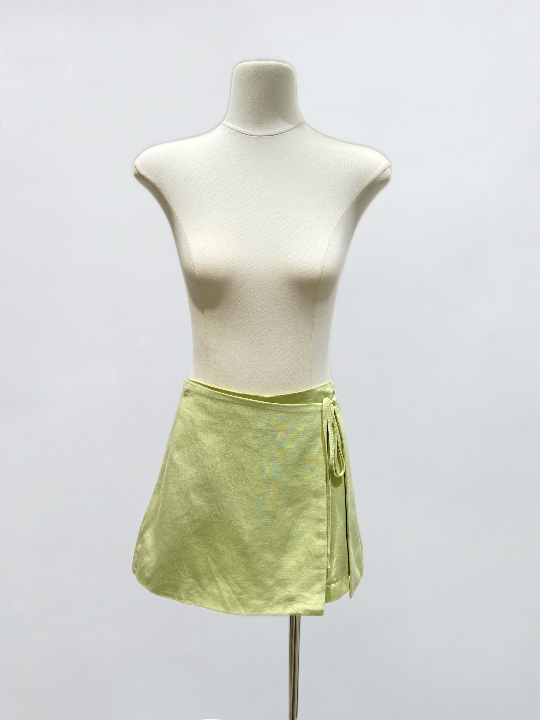 Grossiste IVIVI - Jupe-short en vert clair, modèle portefeuille noué sur le côté.