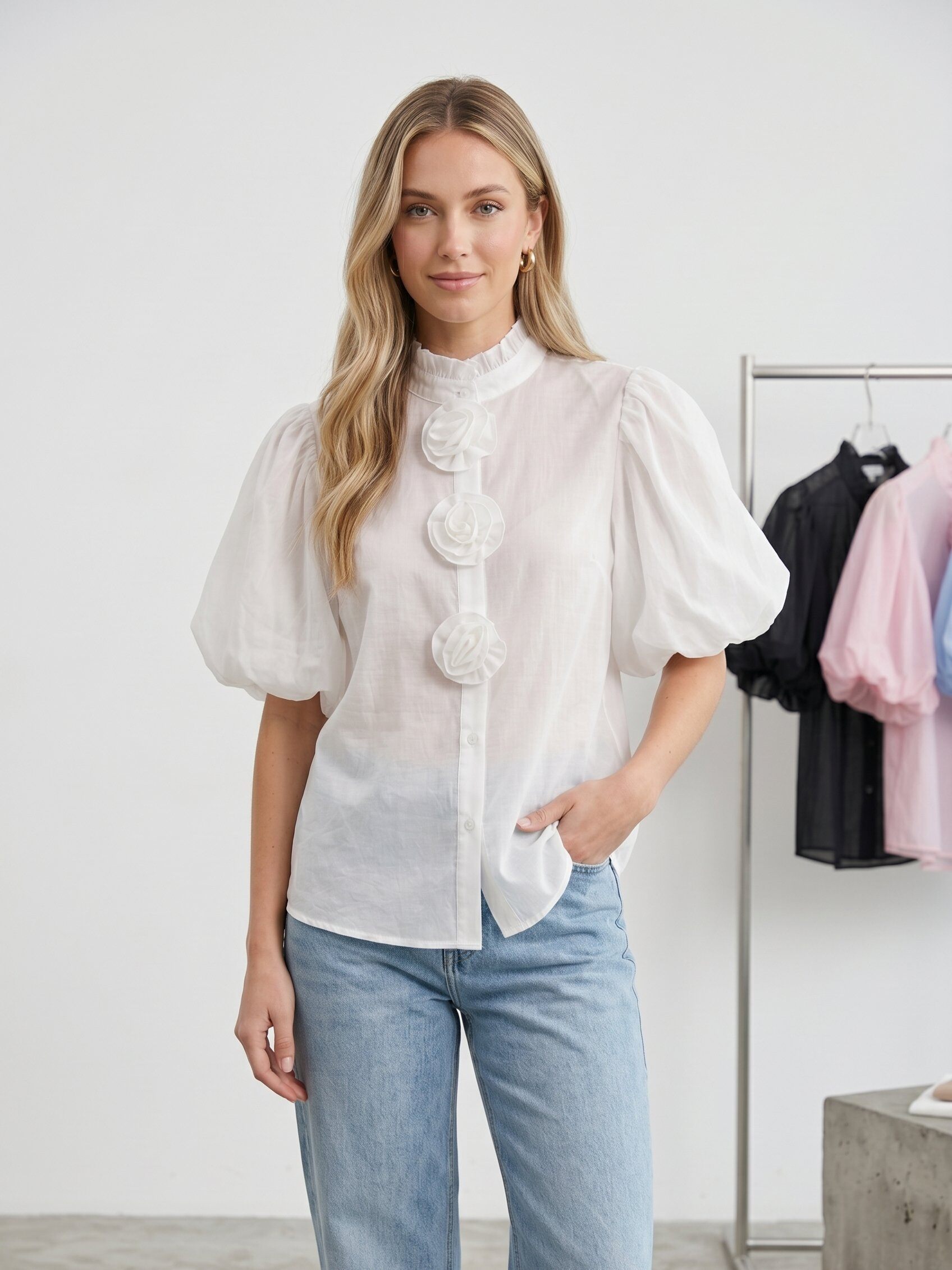 Grossiste J&H Fashion - Blouse féminine à manches bouffantes et col montant, ornée de fleurs en tissu sur la patte de boutonnage.