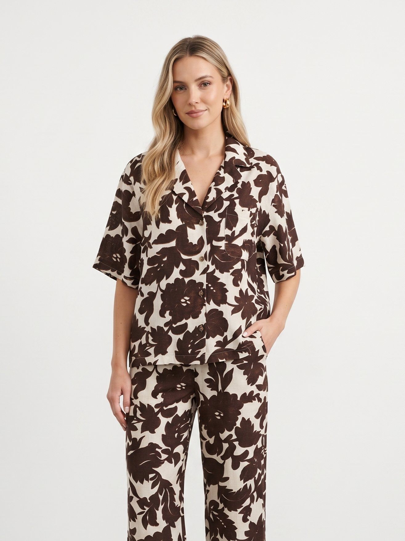 Mayorista J&H Fashion - Una camisa de manga corta con botones adornada con un gran estampado de follaje floral.