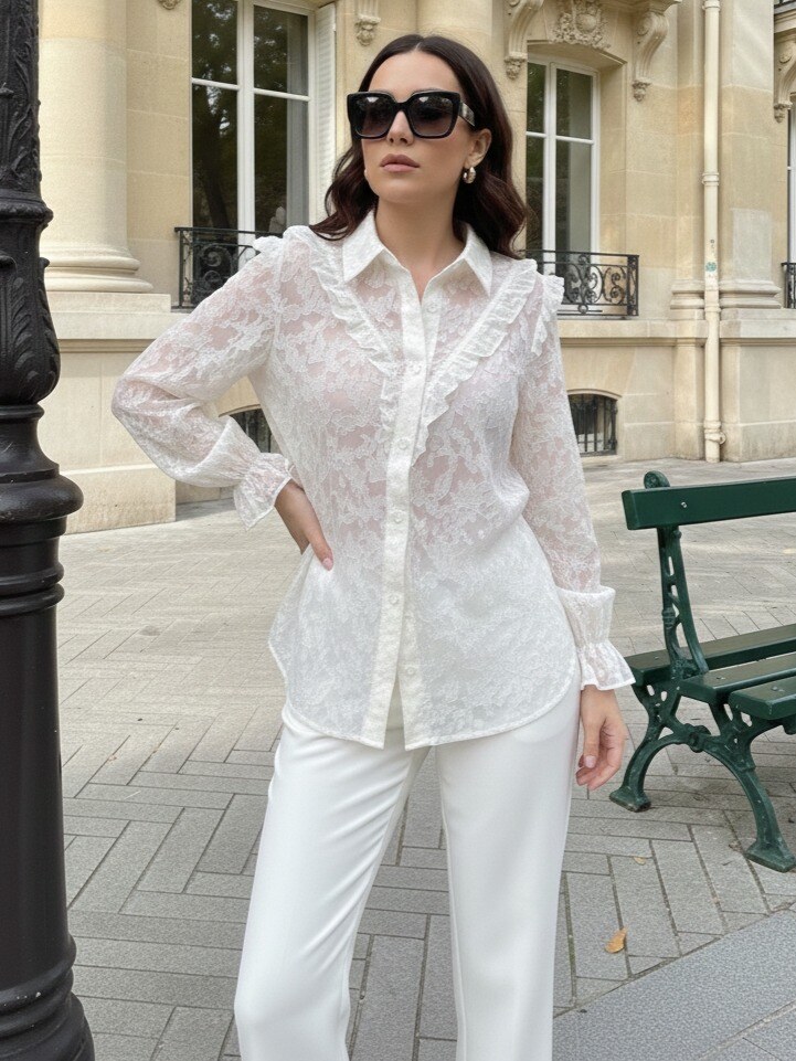 Grossista J&H Fashion - Camicia elegante a maniche lunghe realizzata in tessuto testurizzato con delicati motivi floreali, arricchita da sofisticati volant lungo la linea dei bottoni