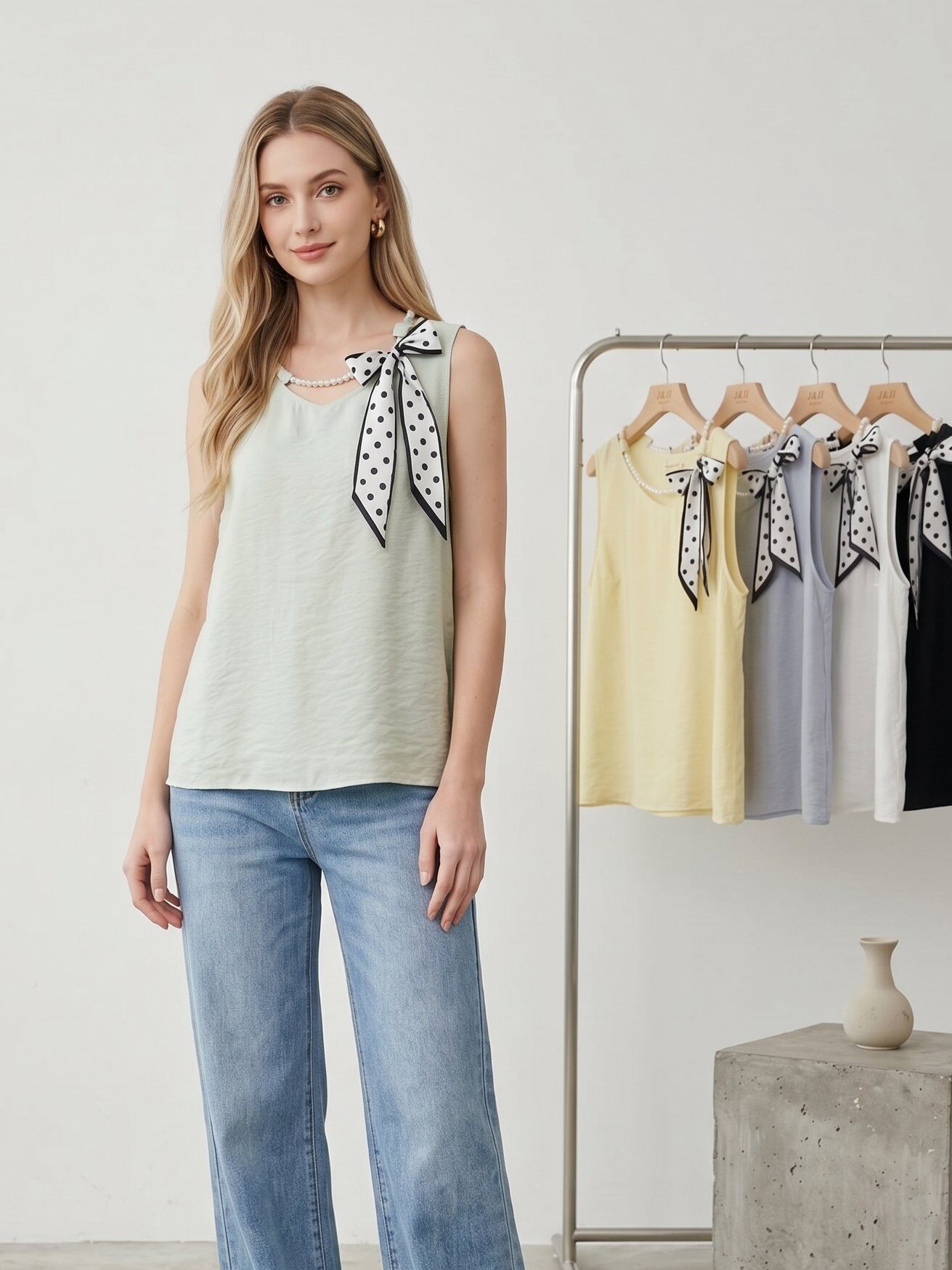 Großhändler J&H Fashion - Fließendes ärmelloses Oberteil mit integriertem Perlenhalsband und einer gepunkteten Schleife auf der Schulter.