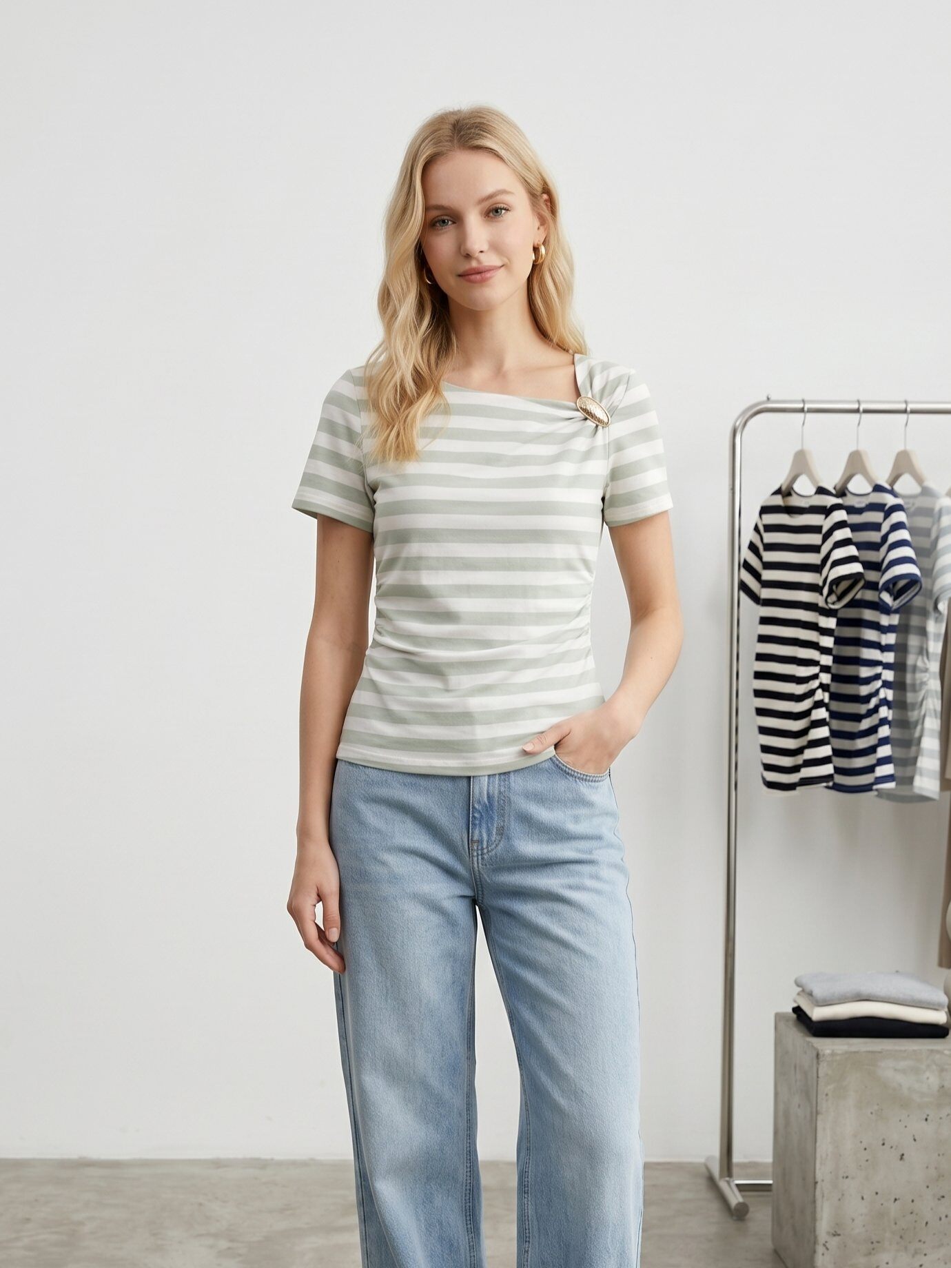 Grossista J&H Fashion - Top a maniche corte ornato di righe orizzontali, con un elegante dettaglio drappeggiato sul lato tenuto da una fibbia in metallo dorato.