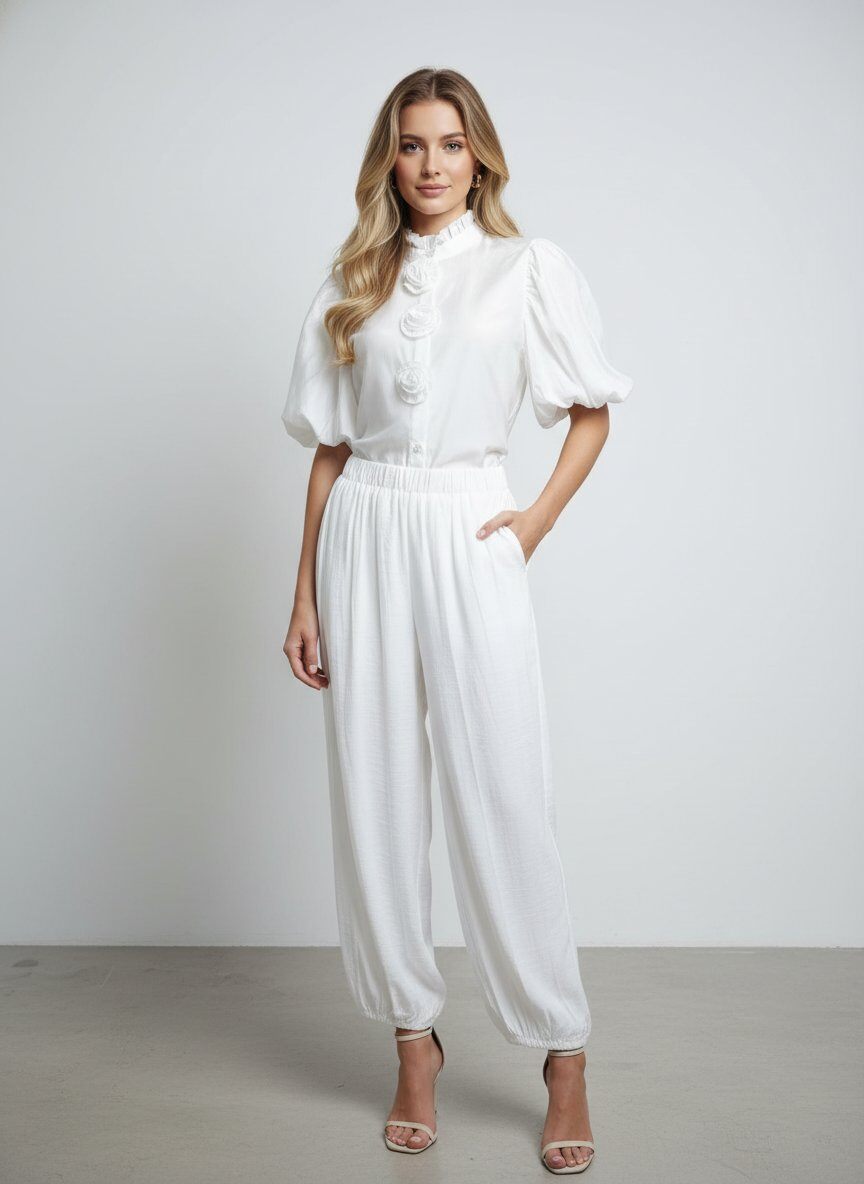 Mayorista J&H Fashion - Conjunto está compuesto por una blusa de cuello alto adornada con flores en relieve y un pantalón fluido ajustado en los tobillos.