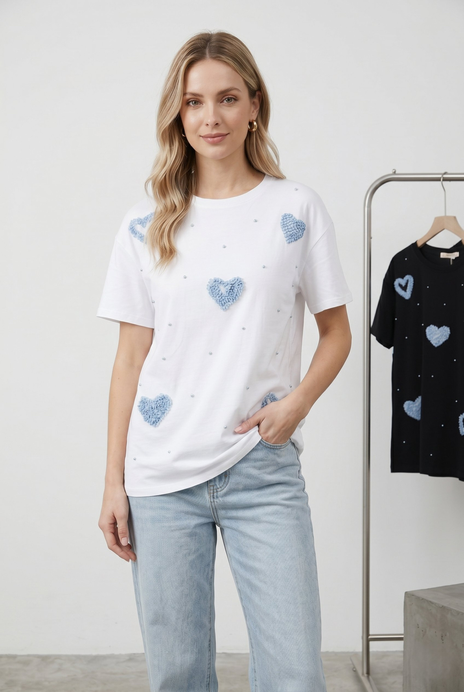 Großhändler J&H Fashion - Kurzarm-T-Shirt mit lässigem Schnitt, verziert mit strukturierten Herzmustern und zarten erhabenen Perlen.