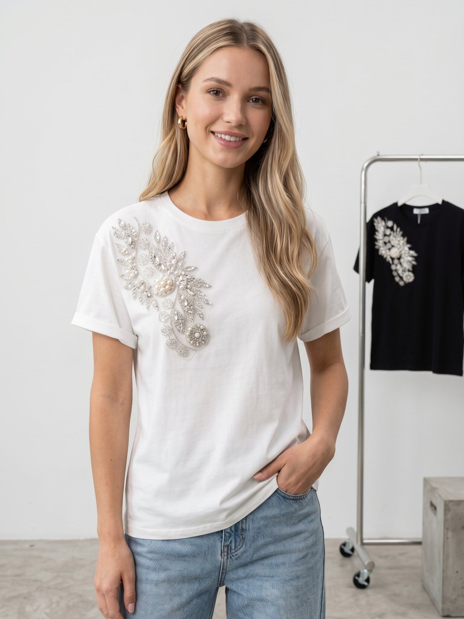 Großhändler J&H Fashion - Kurzarm-T-Shirt verziert mit einer eleganten floralen Reliefstickerei, bestehend aus Perlen und funkelnden Pailletten auf der Schulter.