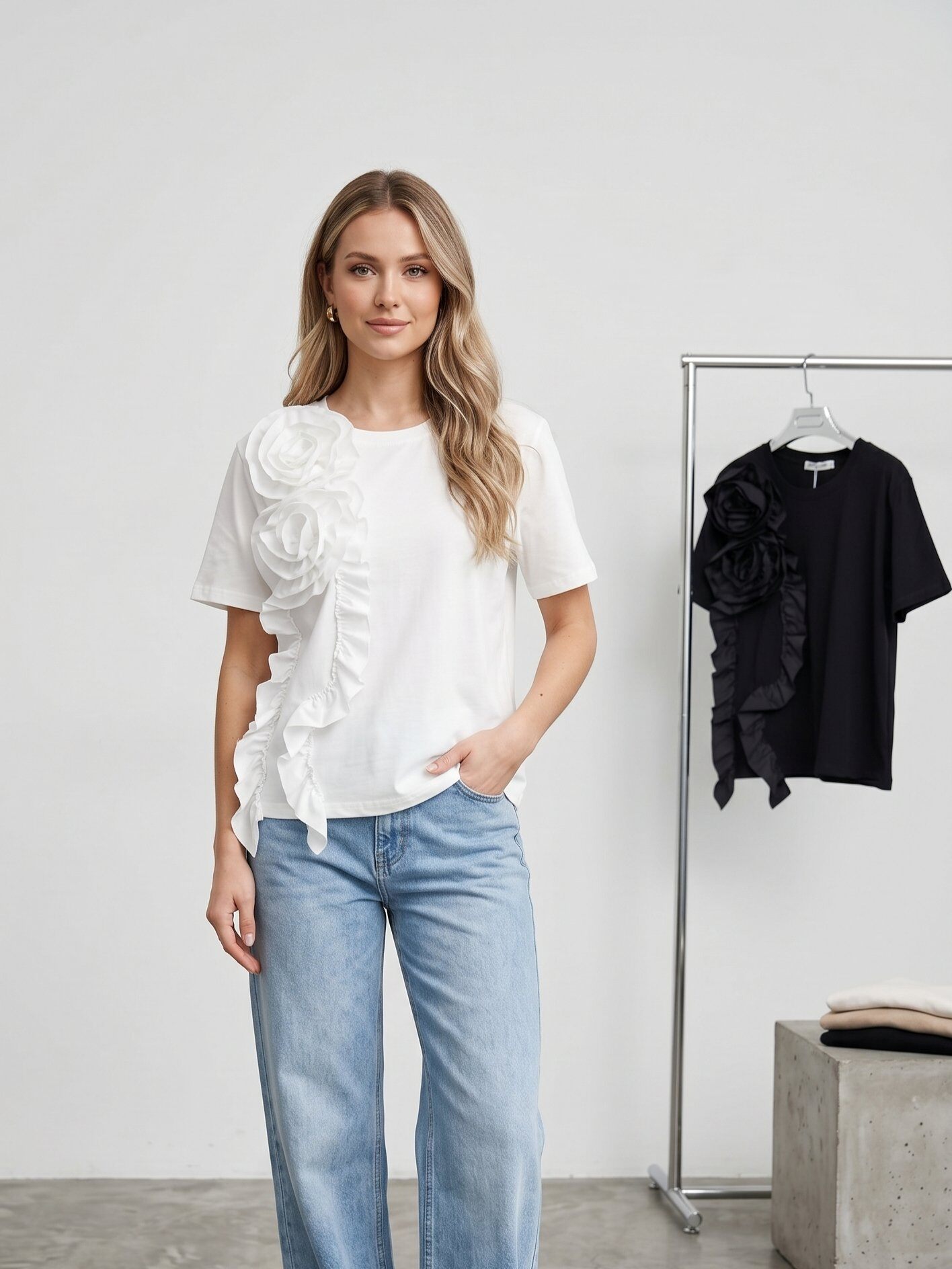 Großhändler J&H Fashion - Baumwoll-T-Shirt mit schlichtem Design, veredelt durch einen eleganten Blumenbesatz in Relief und romantische asymmetrische Rüschen auf der Vorderseite.