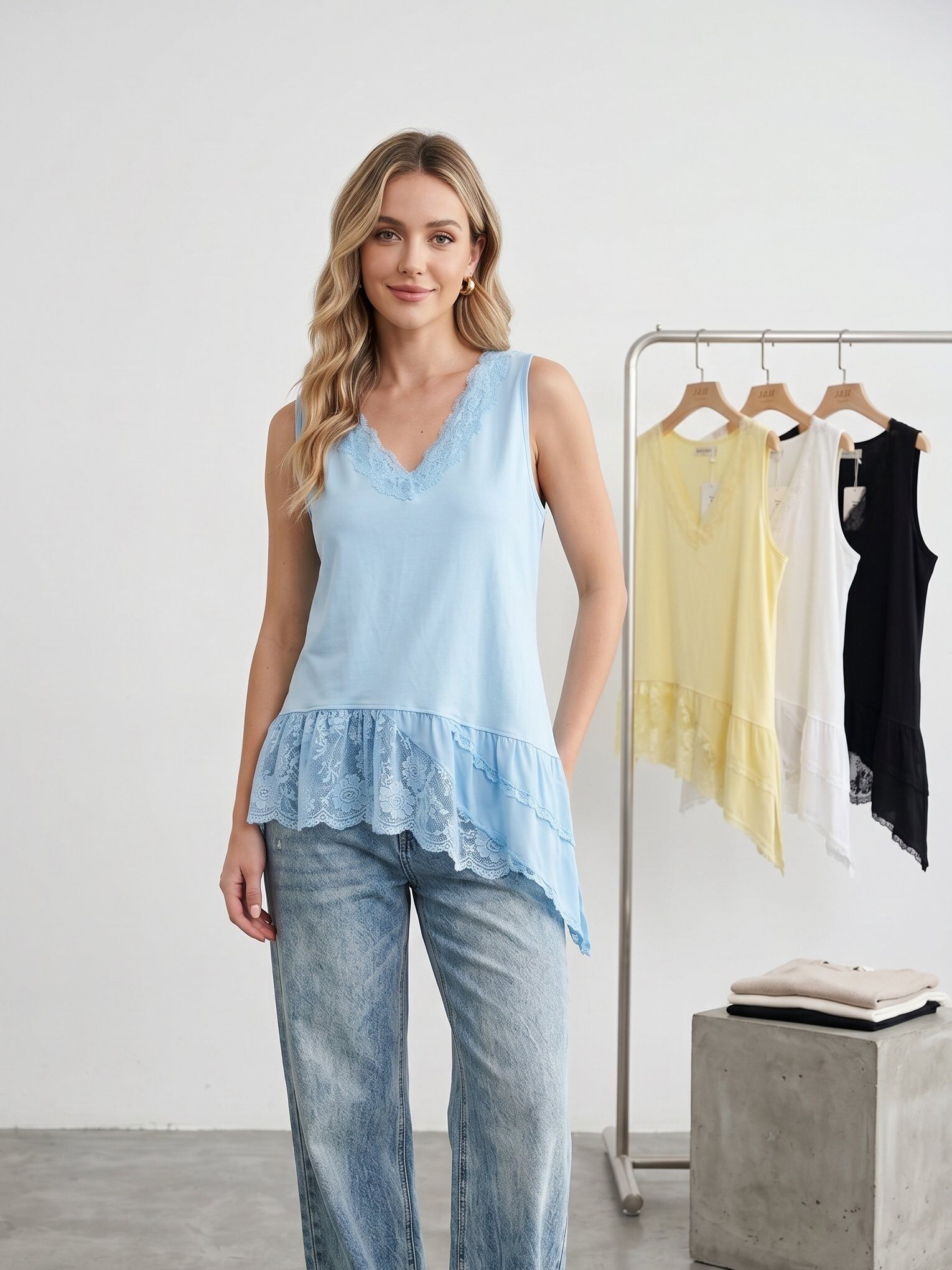 Mayorista J&H Fashion - Camiseta sin mangas fluida con cuello en V adornada con encaje delicado, caracterizada por un corte asimétrico con volantes y acabados románticos.
