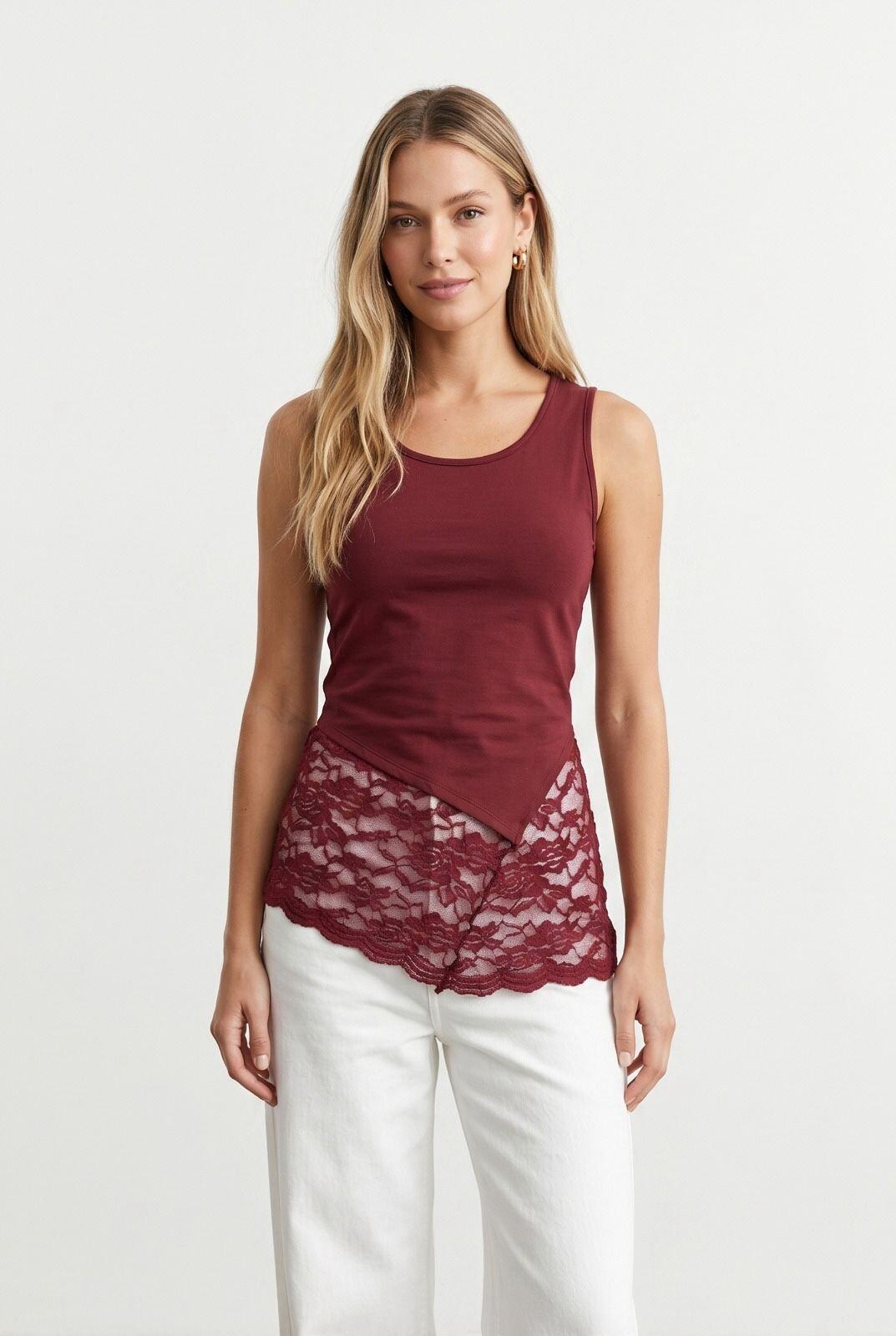 Mayorista J&H Fashion - Elegante camiseta sin mangas presenta un corte asimétrico refinado adornado con un amplio borde de delicado encaje floral en la base.