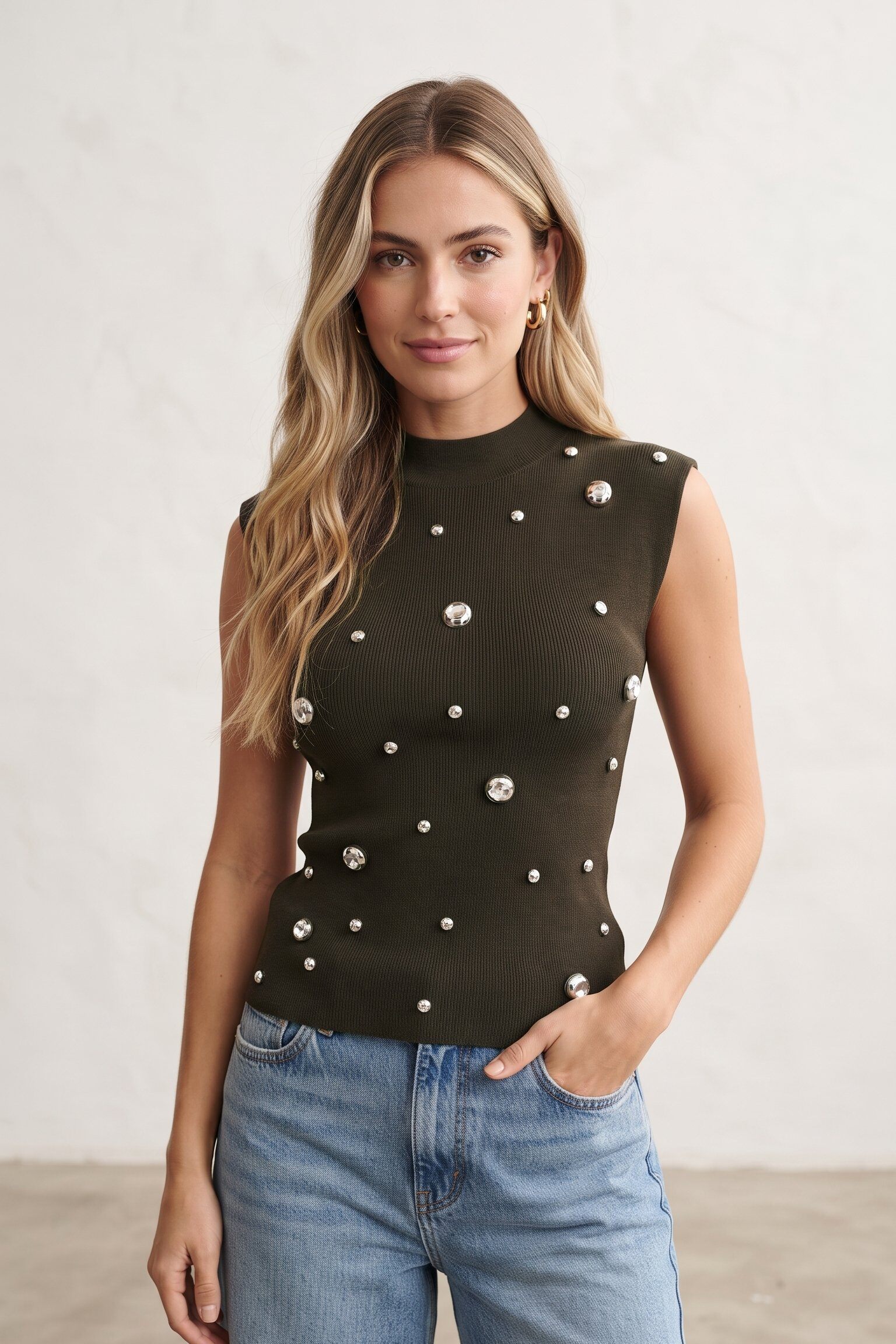 Großhändler J&H Fashion - Ärmelloses Stricktop mit hohem Kragen, verziert mit Perlen und auf der Vorderseite angebrachten metallischen Strasssteinen.