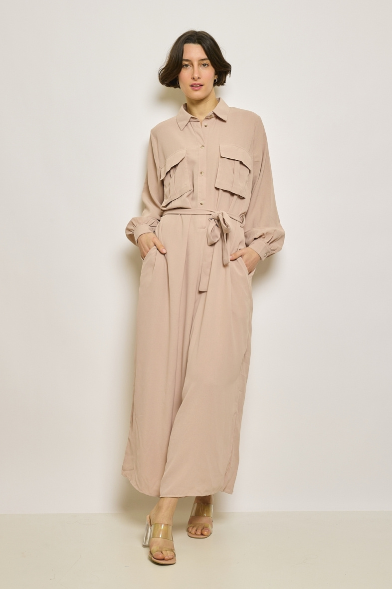 Grossiste JCL Paris - Combinaison pantalon à ceinture à nouer, équipée de deux poches poitrine. Cette pièce complète peut être associée à des talons pour un look classique ou à des baskets pour un style plus décontracté.