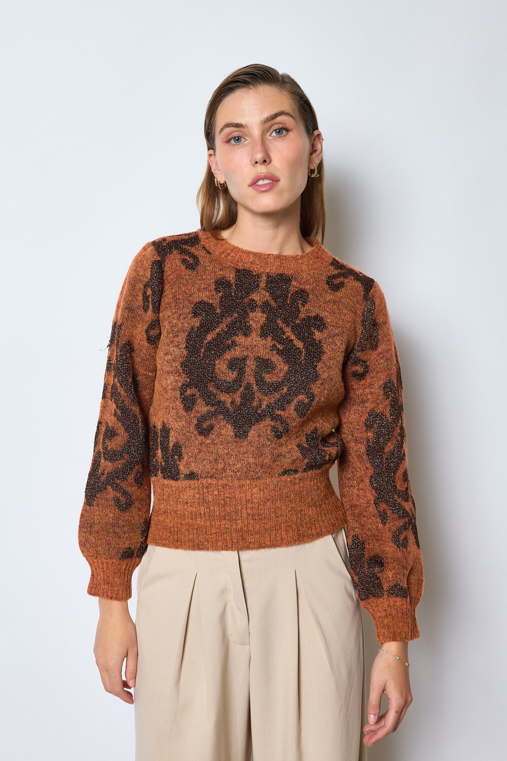 Grossiste JCL Paris - Pull en maille avec manches longues et col rond. Motifs en relief sur le devant créant un contraste de textures. Coupe légèrement ajustée à la taille avec un bas côtelé pour une finition nette.
