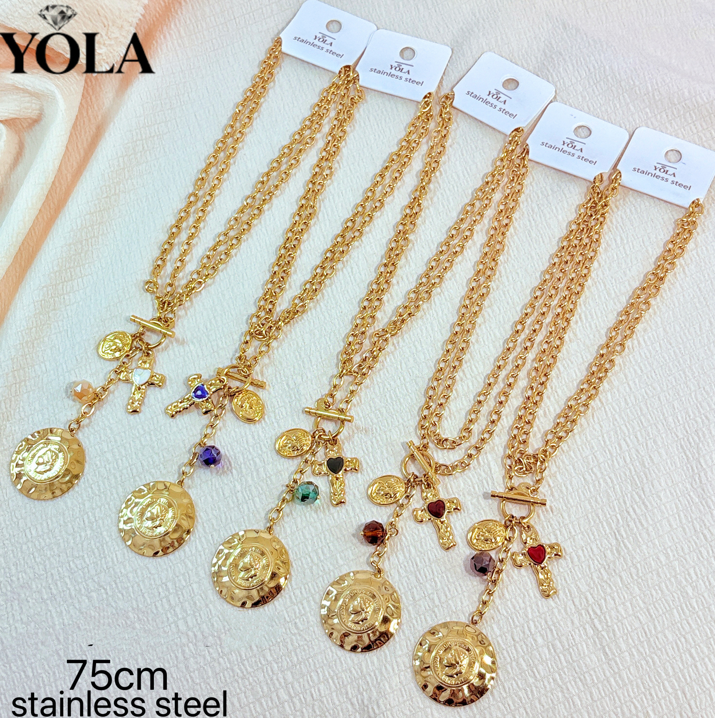 Grossista JESSICA - Si tratta di una lunga collana con medaglione a croce e ritratto vintage, realizzata in acciaio inossidabile, con una lunghezza della catena di 75 cm. La collana presenta una struttura a catena cubana spessa, abbinata a una chiusura OT. Il pendente includ