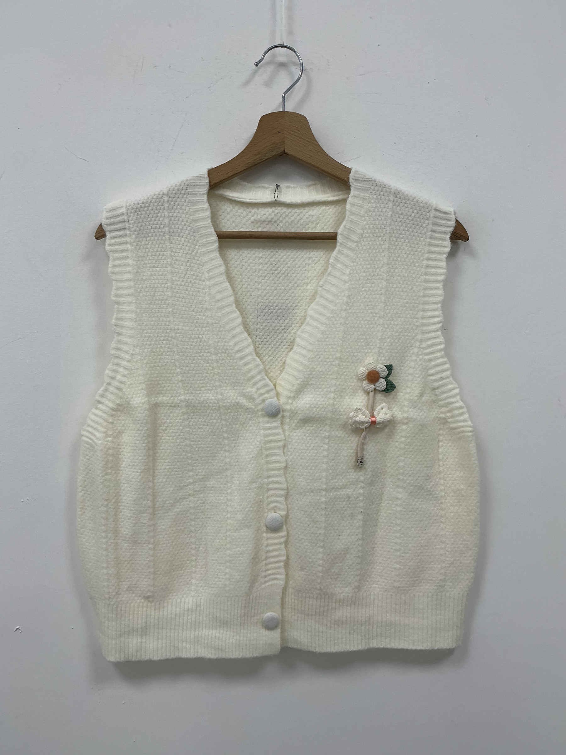 Mayorista KIS₂ - CHALECO DE PUNTO SIN MANGAS ESCOTE EN V APERTURA FRONTAL CON DECORACIÓN EN 3D EN FORMA DE FLOR Y LAZO DISPONIBLE EN VARIAS TALLAS