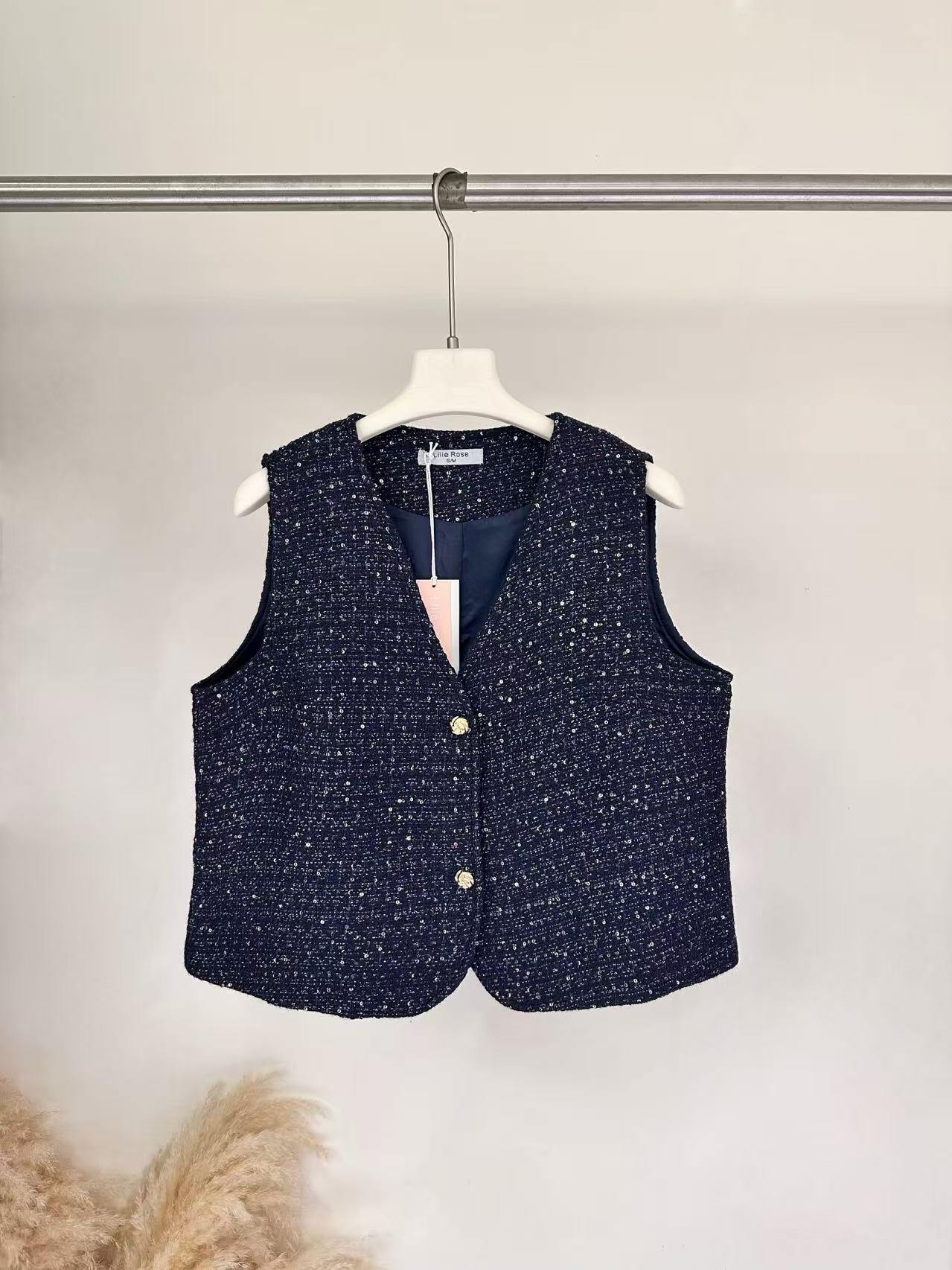 Grossiste Lilie Rose - Gilet sans manches texturé à col en V avec fermeture à boutons dorés.