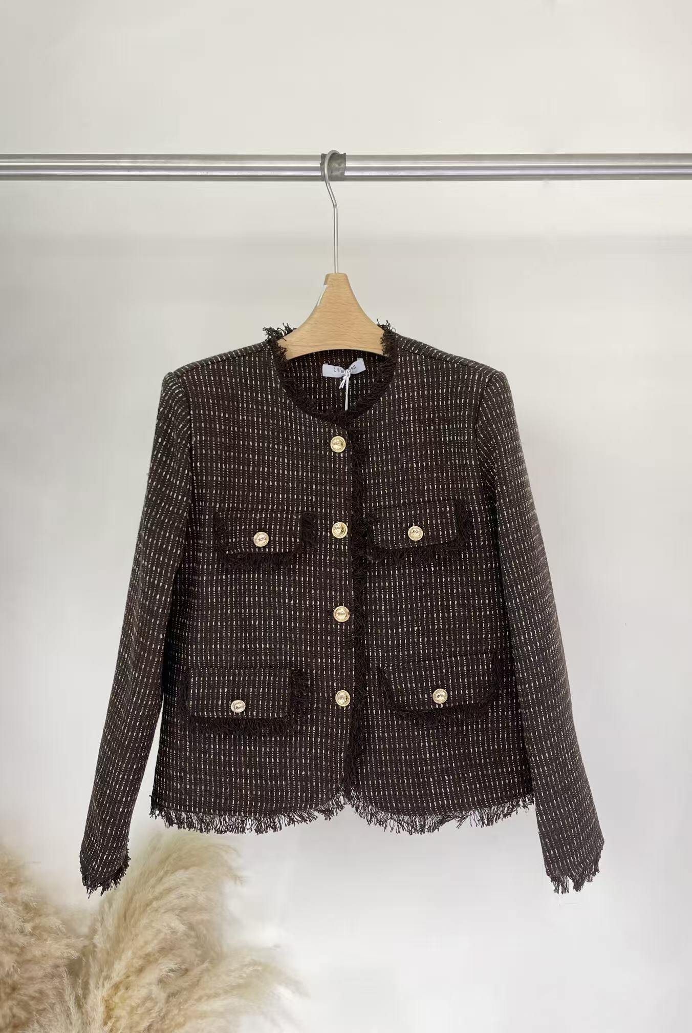 Grossiste Lilie Rose - Veste élégante en tissu texturé, avec boutons dorés, poches à rabat et finitions effilochées.