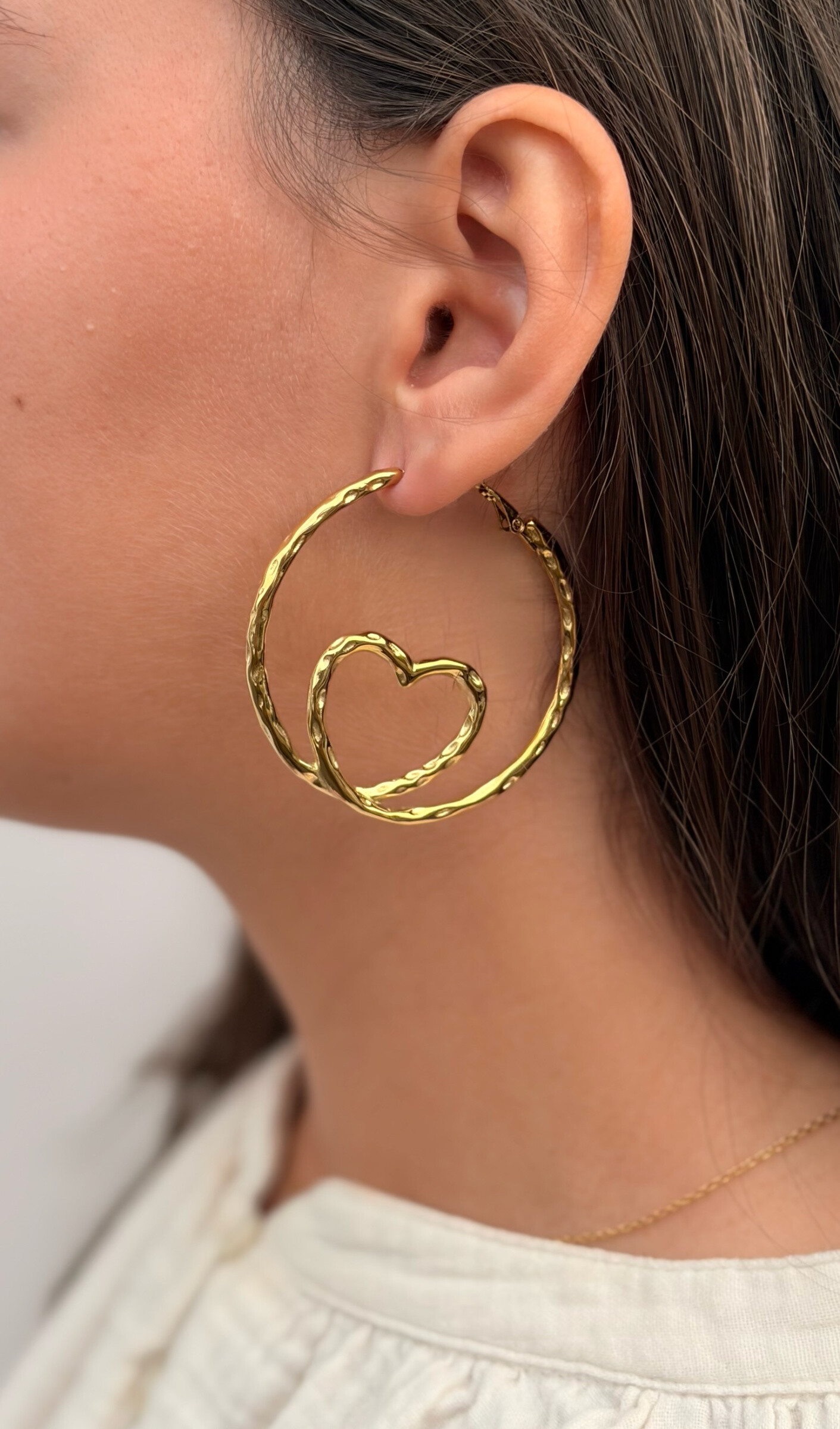 Explore these stainless steel earrings, blending elegance and originality. Their heart-shaped design with a textured pattern adds a modern touch, while the clasp ensures a secure fit. Perfect for a chic yet casual style. Okami House.