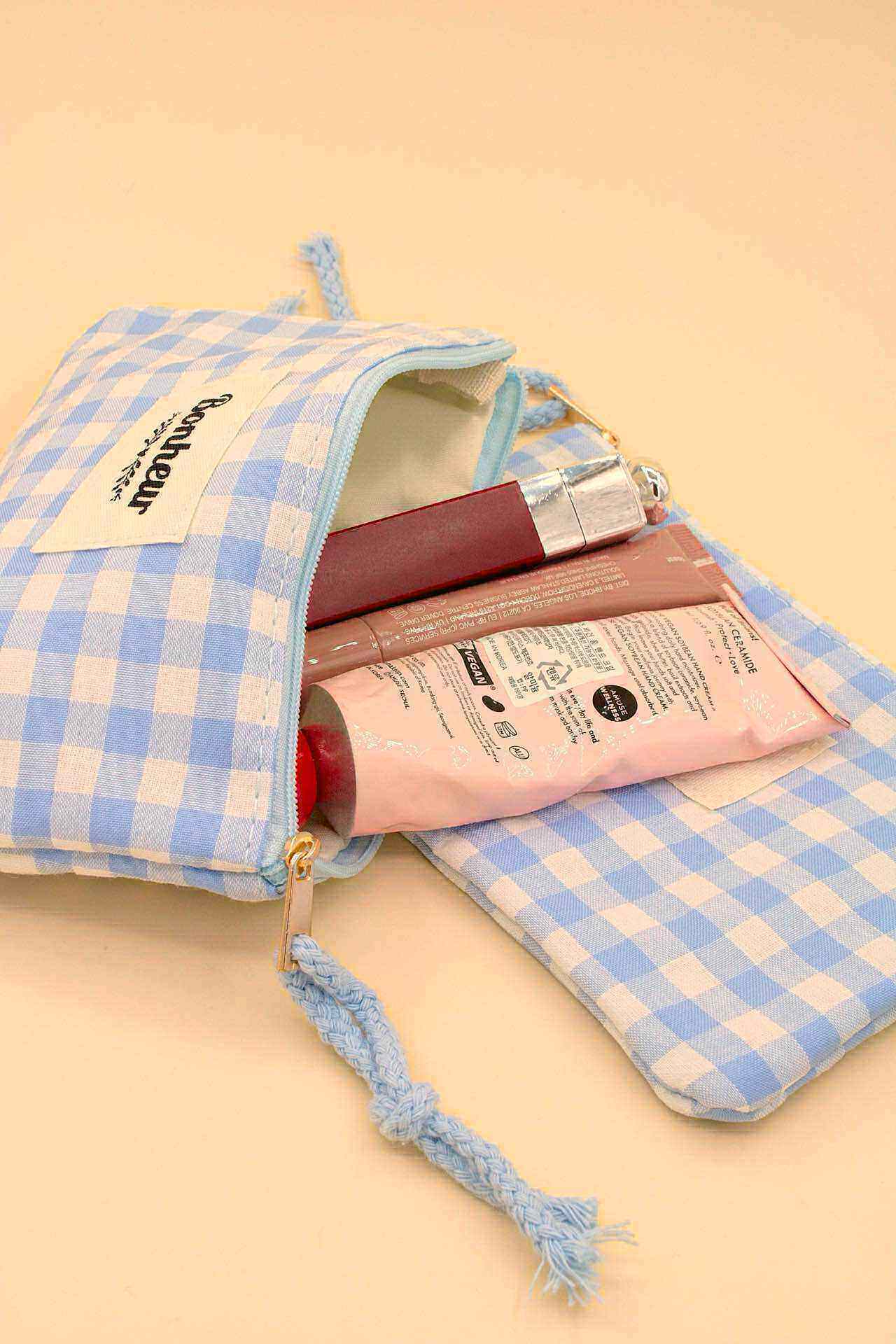 Grossista MAISON OKAMI - Pochette a quadri con scritta 'Felicità' e nappina