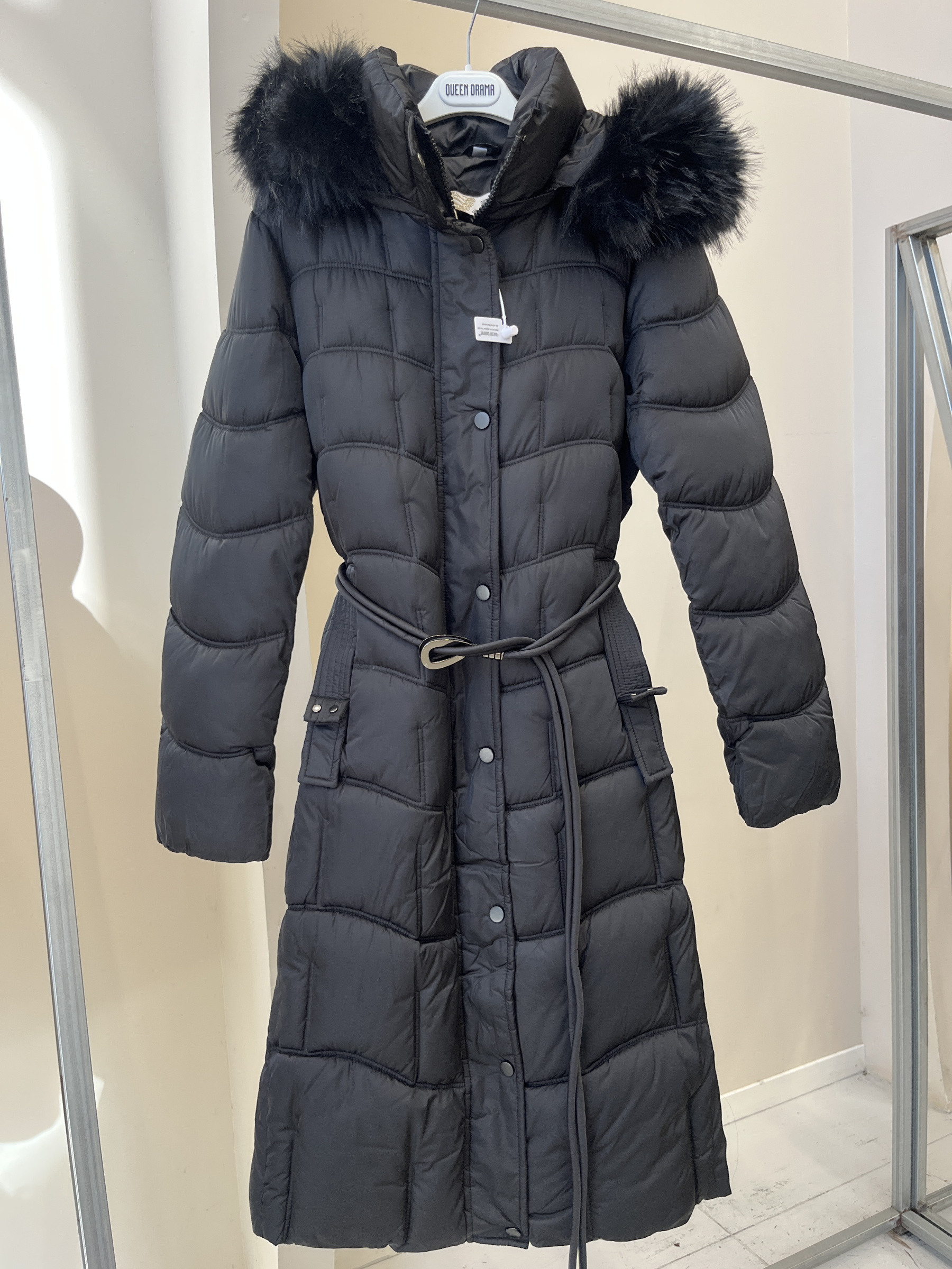 Grossiste QUEEN DRAMA - Doudoune longue avec capuche en fausse fourrure pour femme, avec détails de ceinture, fermeture éclair métallique et accessoires, chaud et élégant