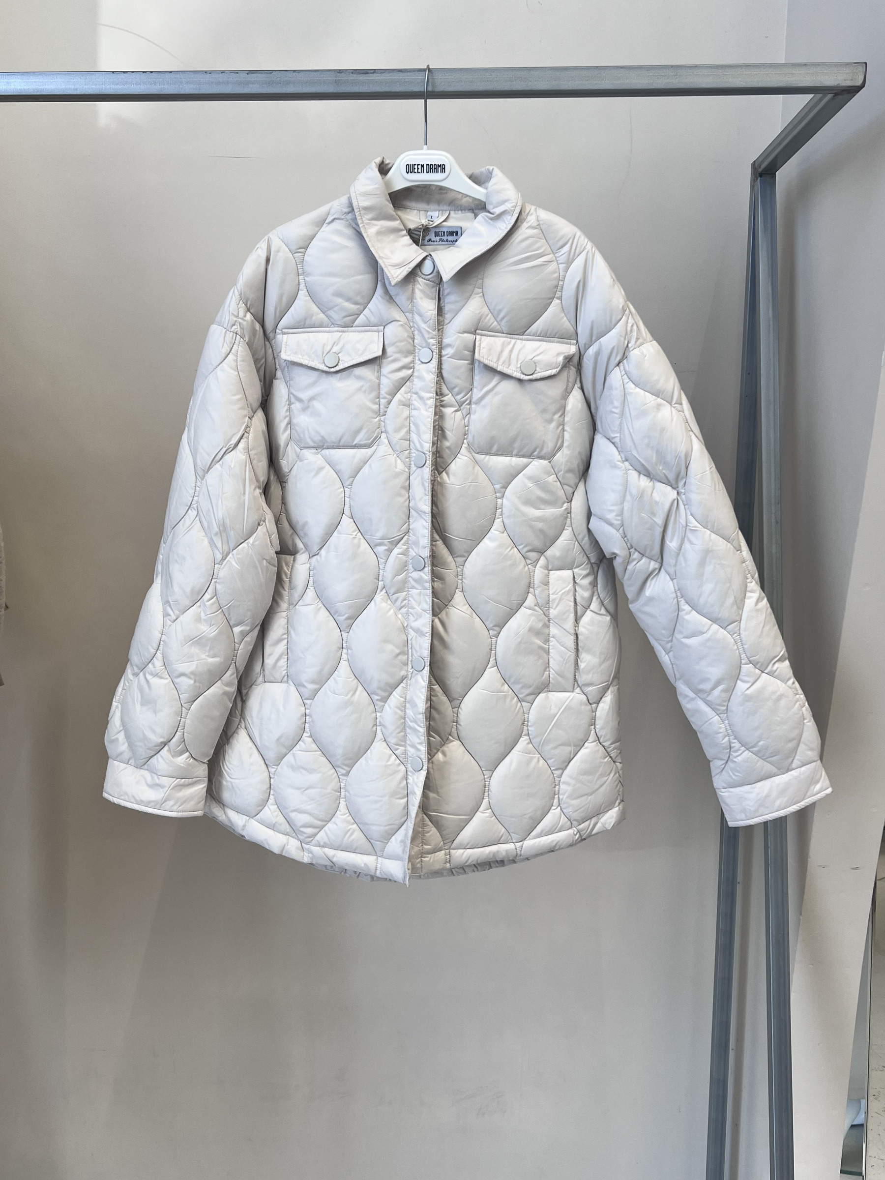 Wholesaler QUEEN DRAMA - Women's quilted jacket with diamond pattern, front button closure, and short cut. With an elegant design, it features long sleeves and two practical front pockets. Lightweight and padded, it's perfect for professional looks and stylish layering.