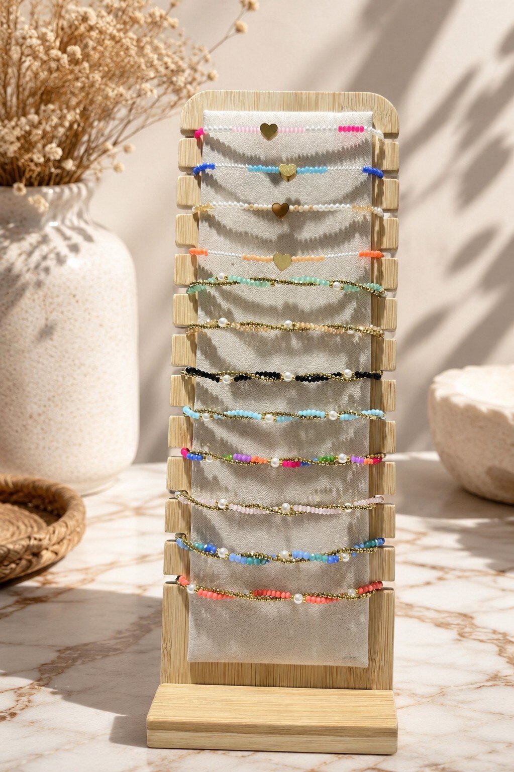 Grossiste ROSE PINK - 12 BRACELETS EN ACIER INOXYDABLE ORNES DE PERLES ET PIERRES COLOREES SU PRESENTOIR EN BOIS