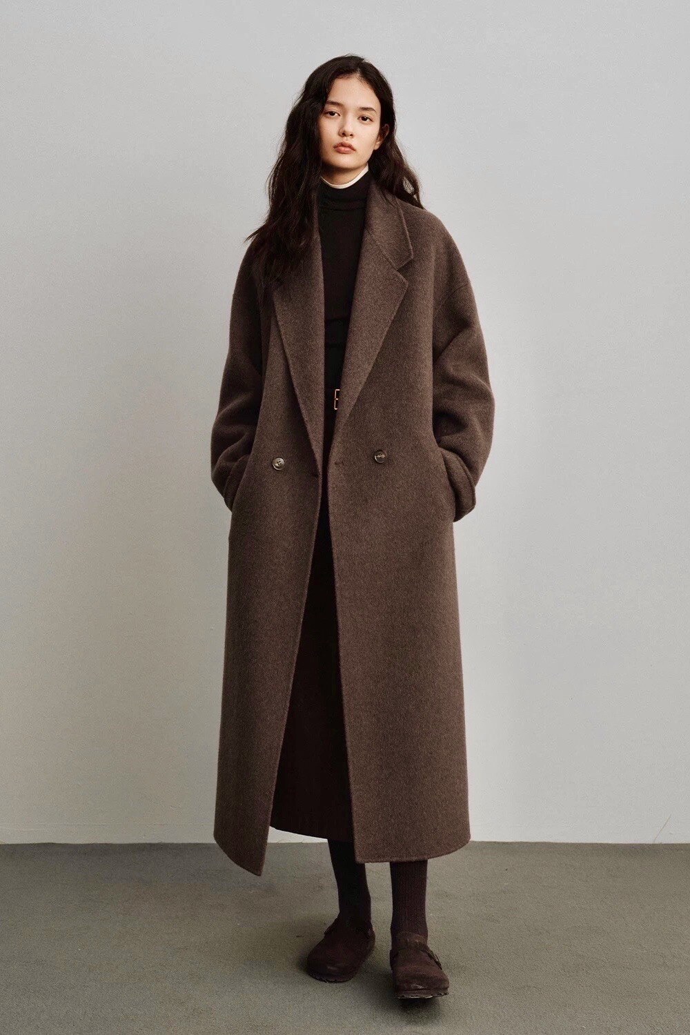 Manteau long oversize en laine mélangée (70% laine, 30% polyester), à la coupe droite et minimaliste, offrant confort et raffinement pour un style intemporel.