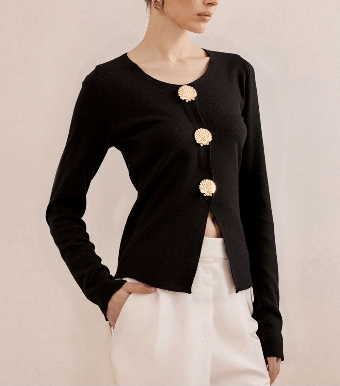 Un pull tendance et raffiné, orné de boutons dorés en forme de coquillage. Sa coupe moderne et son style élégant en font la pièce idéale du quotidien au soir. Disponible en noir et brun.