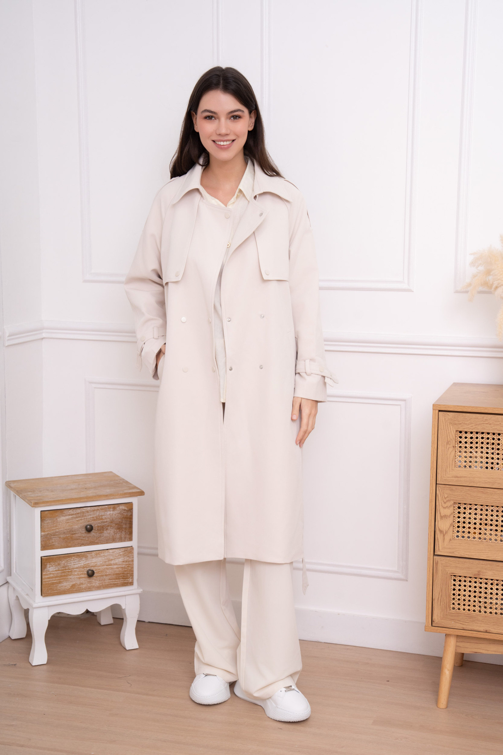 Discover the ideal trench coat: an iconic piece that combines elegance, modernity and comfort. Its long, structured cut naturally highlights the silhouette, while its double-breasted buttoning and storm flap add a touch of sophistication. Thanks to its adjustable belt and its impeccable finishes, this trench becomes the perfect asset to enhance every outfit, from morning to evening.
