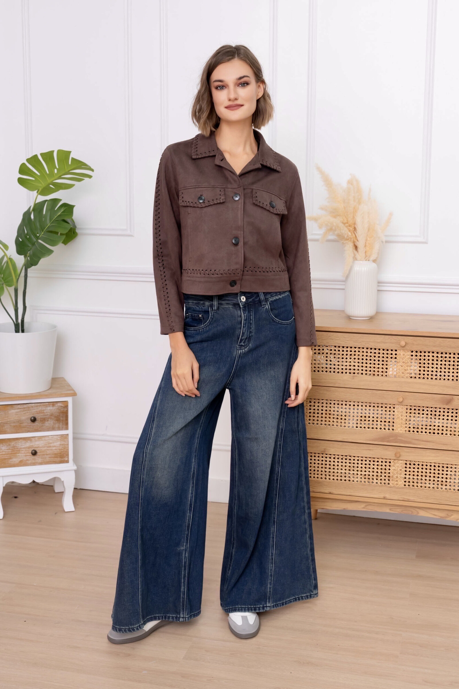 Une veste courte en suédine marron, sublimée par des surpiqûres décoratives façon tressage. Avec ses poches à rabat et ses boutons élégants, elle allie charme authentique et modernité pour un style casual chic. ?