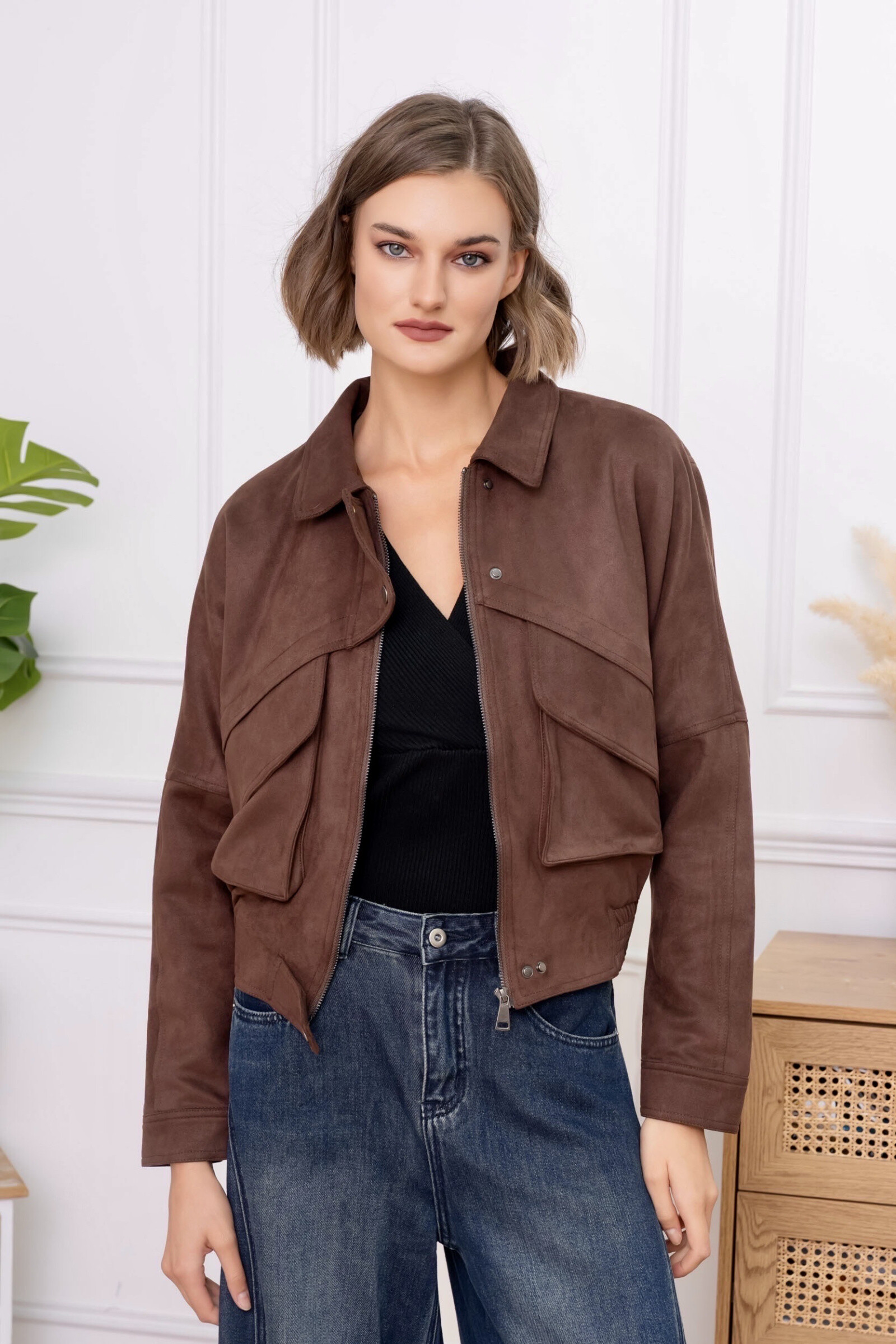 Cette veste courte en daim allie élégance contemporaine et esprit casual chic. Sa matière en daim offre un toucher doux et un aspect raffiné, idéal pour un porté confortable au quotidien. La coupe légèrement ample est équilibrée par une base resserrée, mettant subtilement la silhouette en valeur. La fermeture zippée sur le devant apporte une touche moderne et pratique, tandis que le col classique renforce son style intemporel. Les poches discrètes et les finitions soignées complètent cette pièce polyvalente, parfaite pour composer des looks urbains, décontractés ou élégants avec caractère.