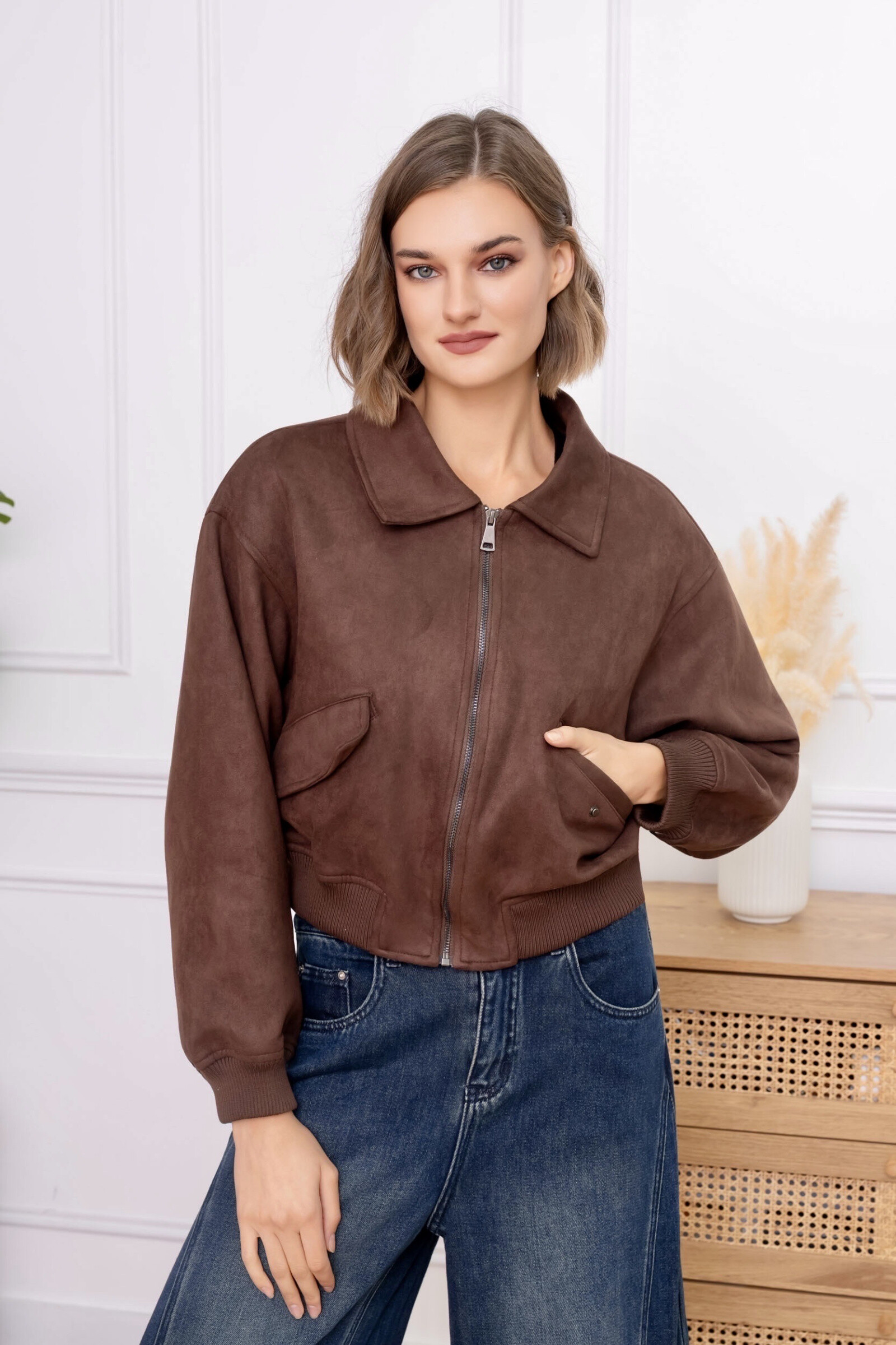 Cette veste courte en daim séduit par son design moderne et son esprit urbain affirmé. Sa matière en daim offre un toucher doux et un rendu élégant, tout en garantissant un confort optimal. La coupe légèrement ample assure une silhouette équilibrée, tandis que la fermeture zippée sur le devant permet un porté pratique et ajustable. Le col classique renforce son style intemporel, et les poignets ainsi que la base resserrés apportent une finition soignée. Une pièce polyvalente et contemporaine, idéale pour composer des looks décontractés ou élégants avec caractère.