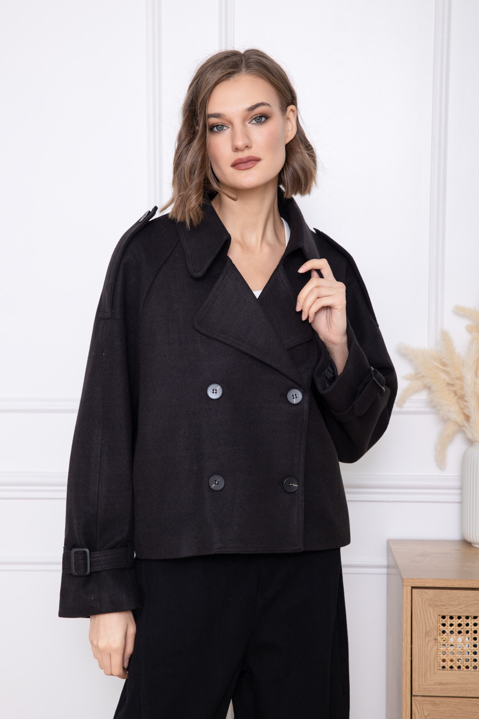 Cette veste courte se caractérise par une coupe structurée et un design inspiré du vestiaire classique revisité de manière moderne. Le double boutonnage sur le devant apporte une touche sophistiquée tout en renforçant l’allure élégante de la pièce. Le col large et les pattes aux poignets soulignent son style affirmé, tandis que la coupe légèrement ample garantit un confort optimal. Le tombé fluide permet une grande liberté de mouvement et une silhouette harmonieuse. Une veste polyvalente, idéale pour composer des looks soignés, à la fois contemporains et intemporels.