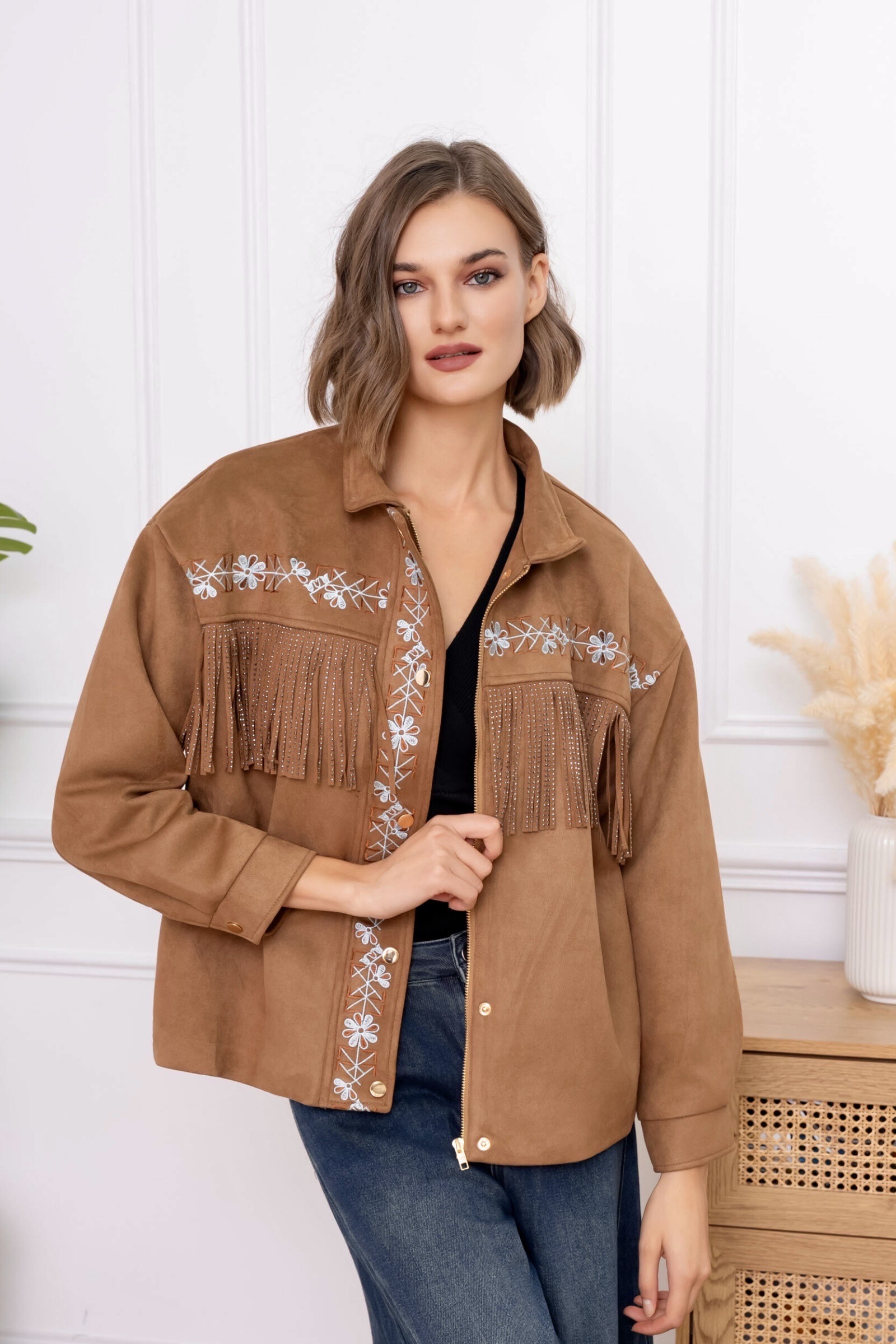 A camel suede jacket decorated with white floral fringes and embroidery. She mixes Cowgirl spirit and romantic details, perfect for a trendy and assertive look. ??