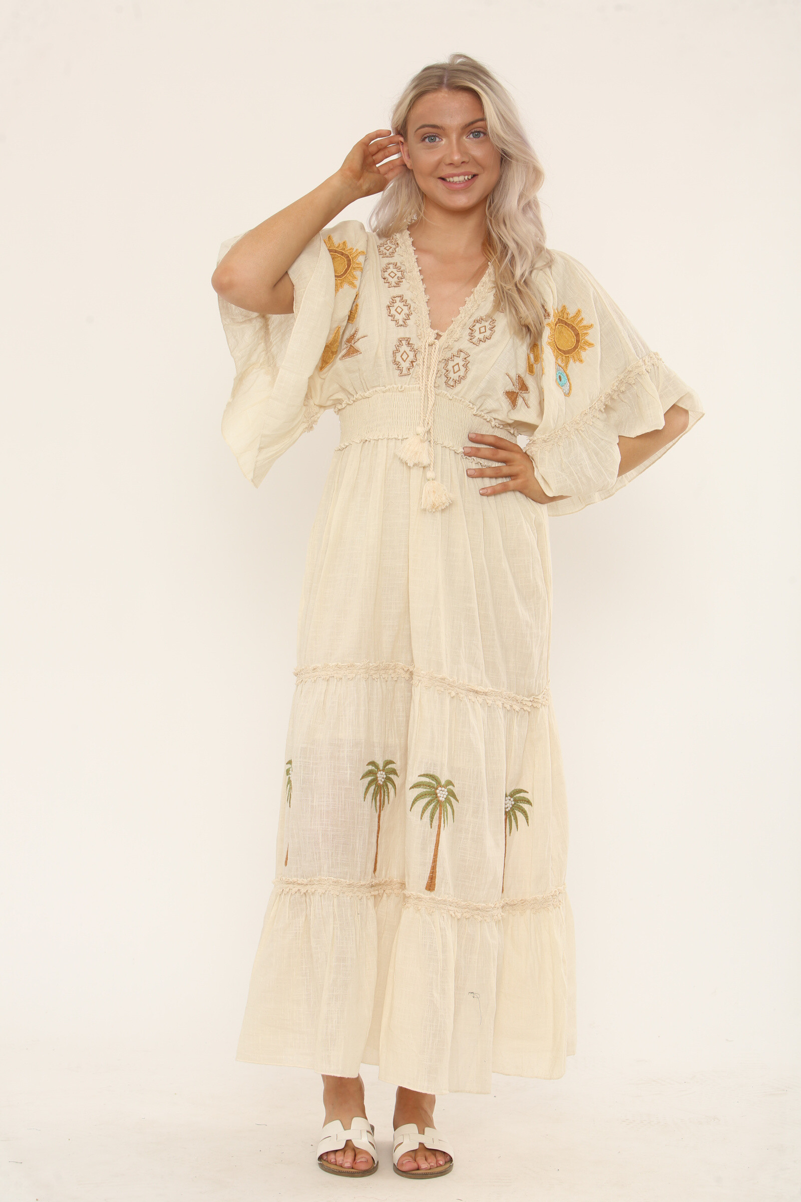 Grossiste TANISHA - Robe longue bohème brodée – Motifs soleil, palmiers et œil protecteur, manches papillon et taille smockée – Ref SK-030