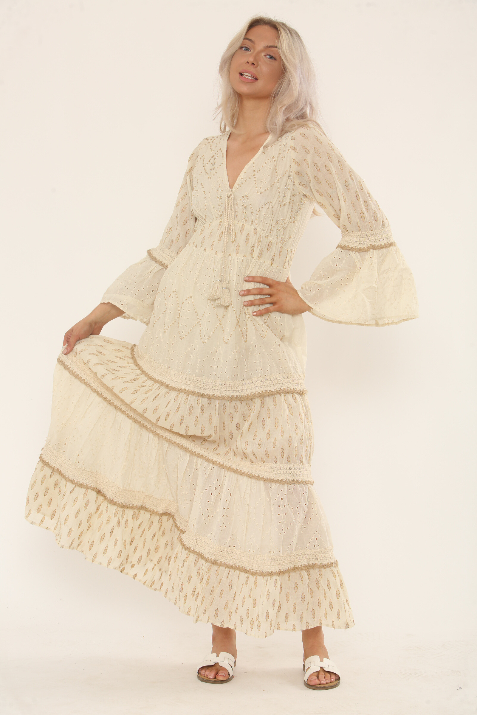 Großhändler TANISHA - Langes Bohème-Kleid aus 100 % cremefarbener Baumwolle - Englische Stickerei und goldene Drucke, ausgestellte Ärmel und Bindeband mit Quasten - Natürliche Eleganz - Ref. ASK-005I