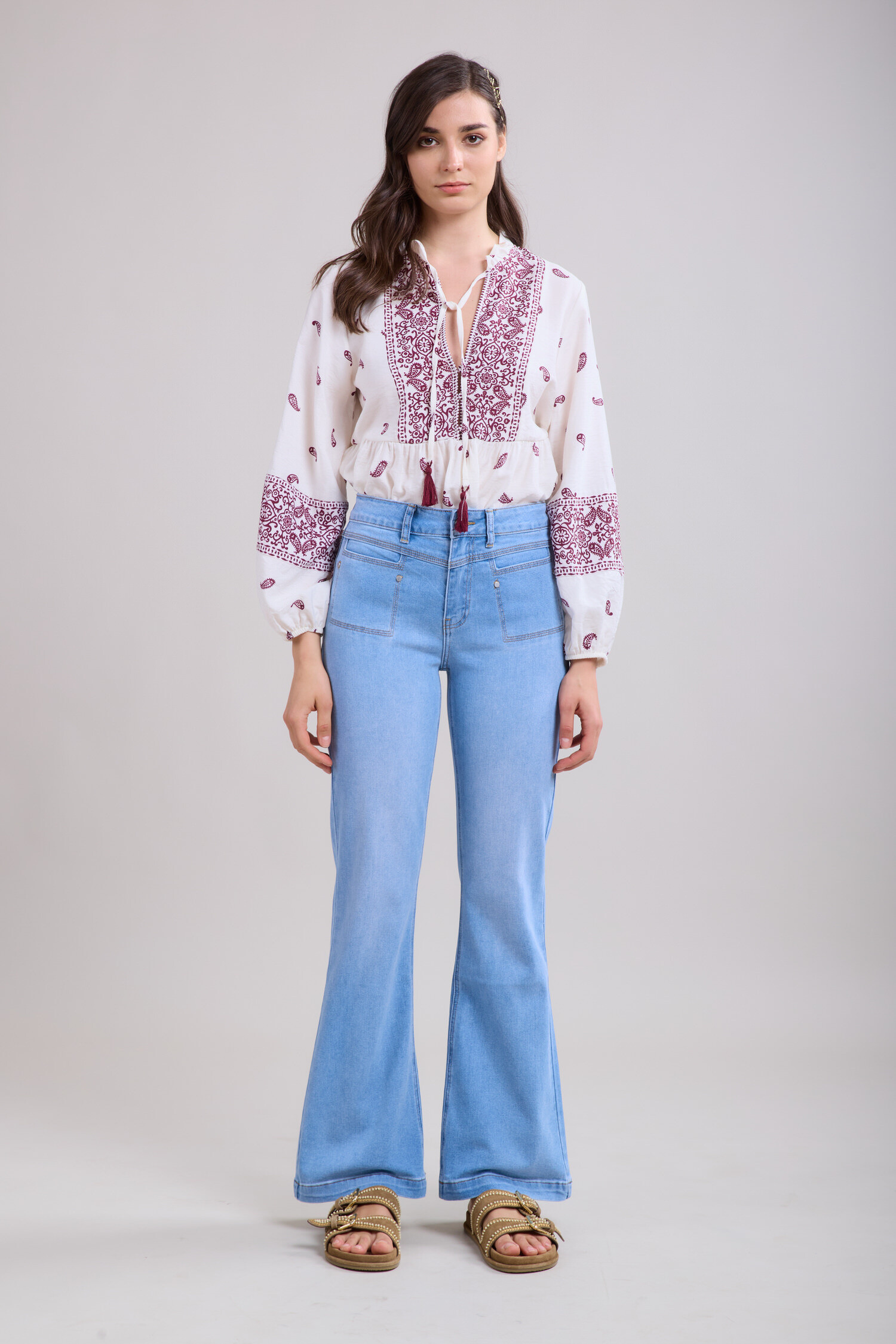 Un jean flare classique en denim bleu, parfait pour une silhouette allongée et un look rétro tendance.