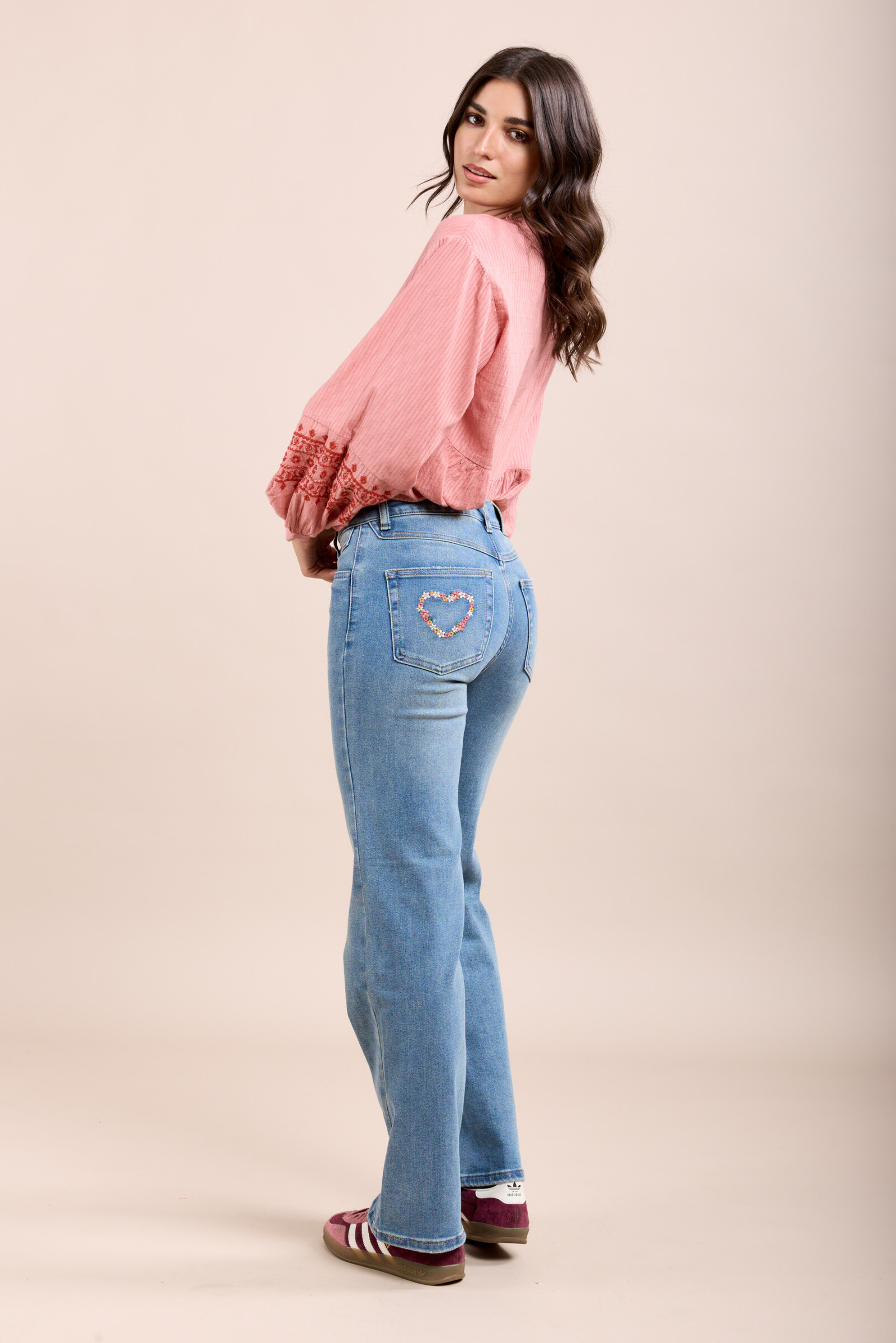 These jeans, crafted from comfortable stretch fabric, feature a straight cut and a zip closure. They stand out with a pocket adorned with heart-shaped embroidery.
